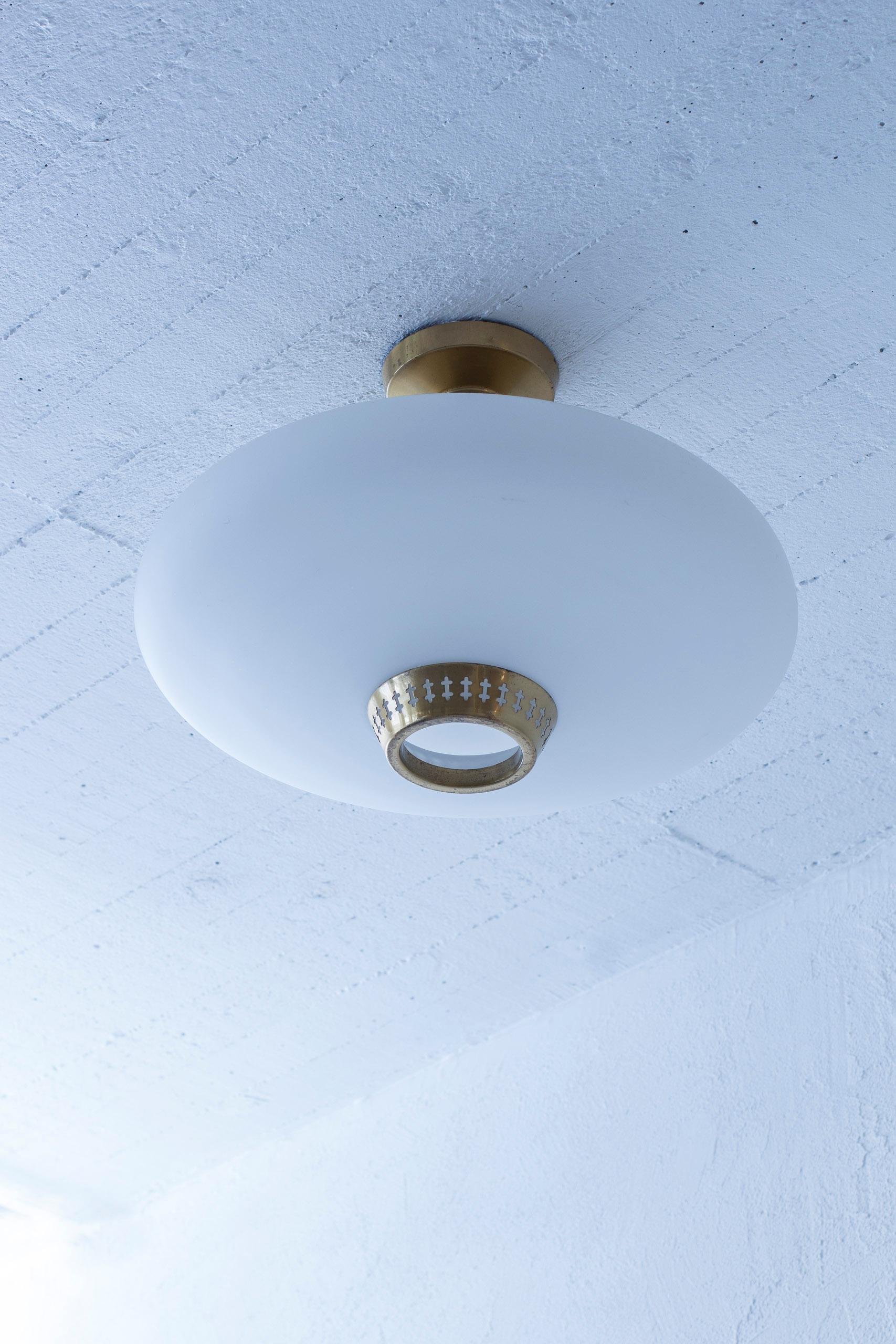 Flush mount ceiling lamp designed by Hans Bergström. Produced by Ateljé Lyktan during the 1950s. Made from polished brass and opal glass shade. Very good vintage condition with age related wear and patina.

Hans Bergström's remarkable design journey