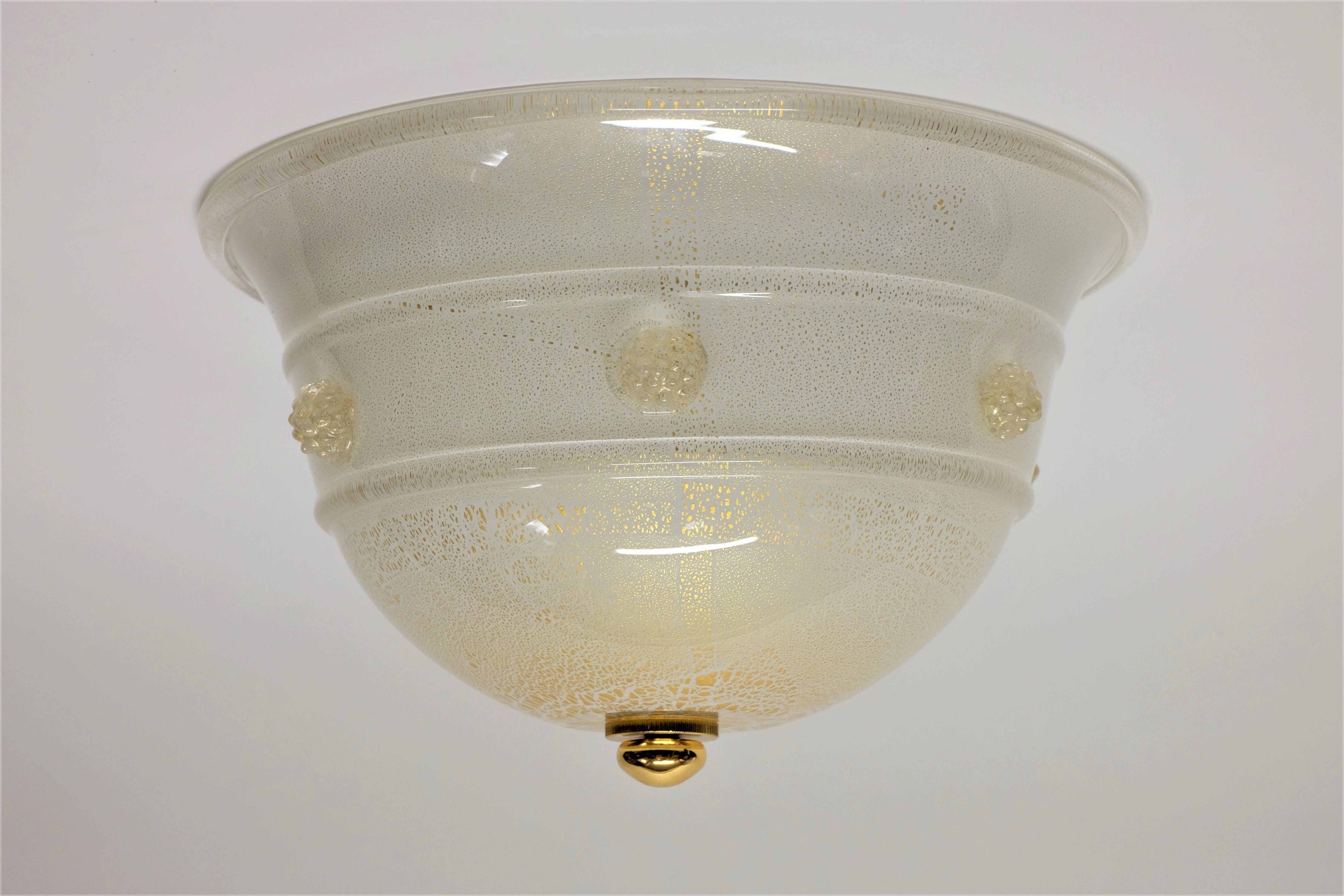 Flush mount ceiling light by Barovier & Toso. Thick opaque glass covered by clear glass with fine scattering of gold flecks. Glass details and florets are in clear and gold. Metal mounting plate in white paint uses 2 bulbs (E14).

The lamp is in a