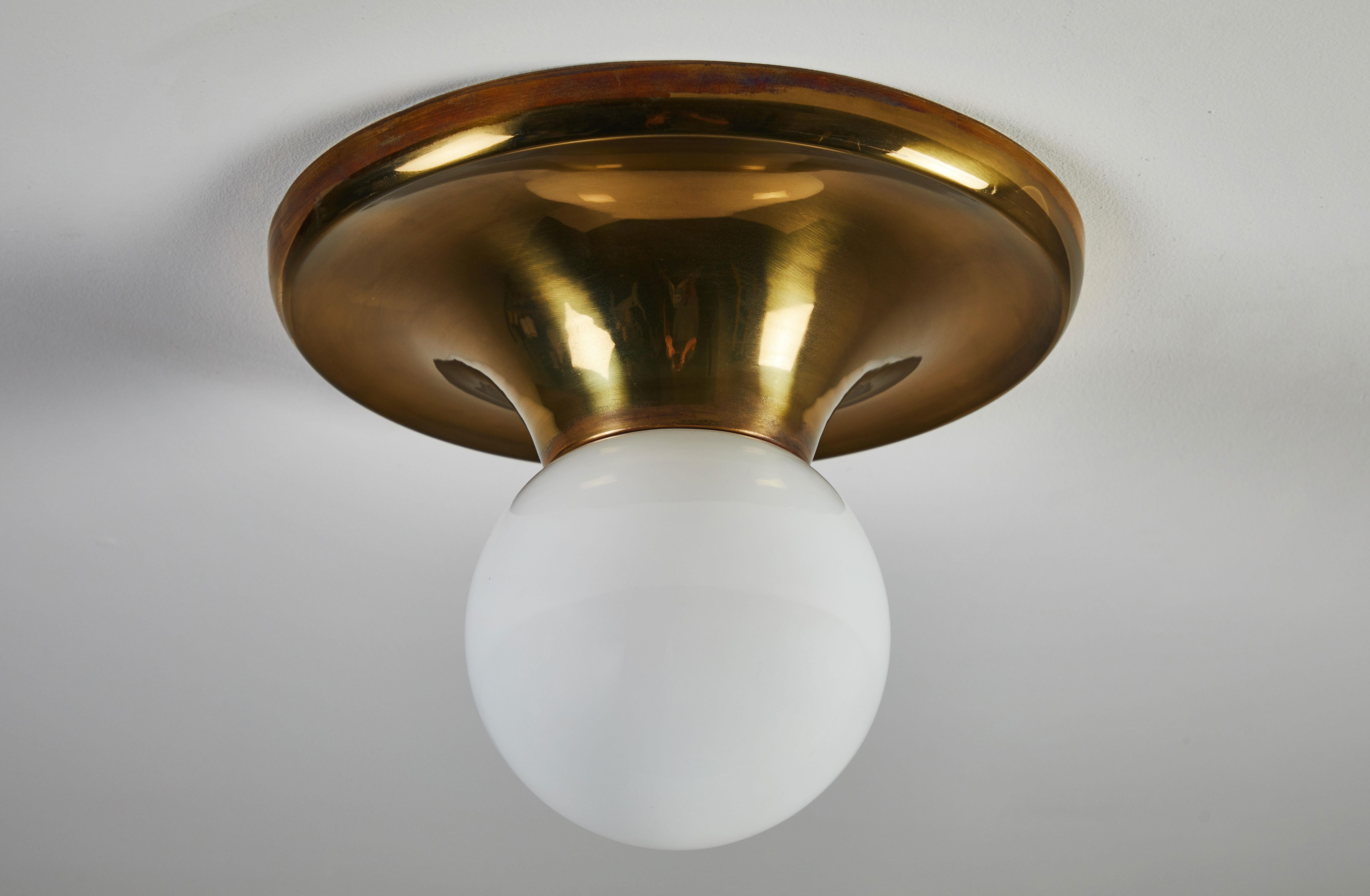 Single flush mount ceiling light by Achille & Pier Giacomo Castiglioni for Flos. Designed and manufactured in Italy, 1965. Brass and opaline glass. Rewired for US junction boxes. Each light takes one E27 100w maximum bulb. Literature: Casa Amica
