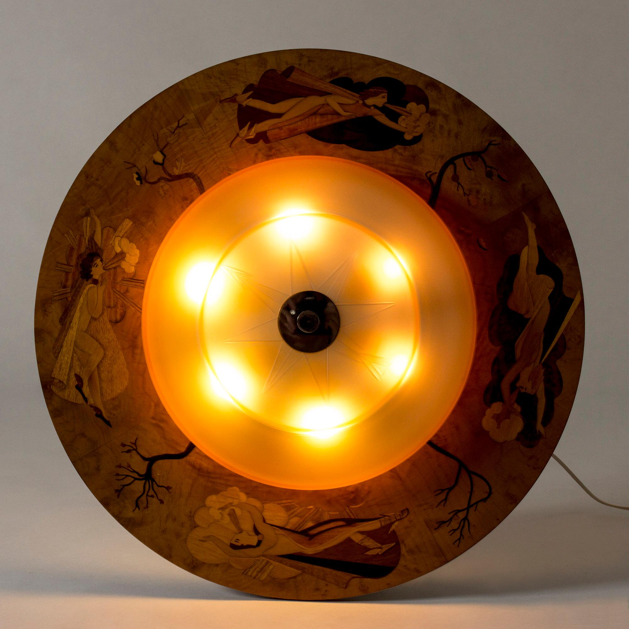 Striking, large 1930s flush mount ceiling light by Birger Ekman. Rare design with a round glass yellow nuance shade with the decor of a compass. Wide wooden frame with beautiful inlays of trees during different seasons and female wind spirits