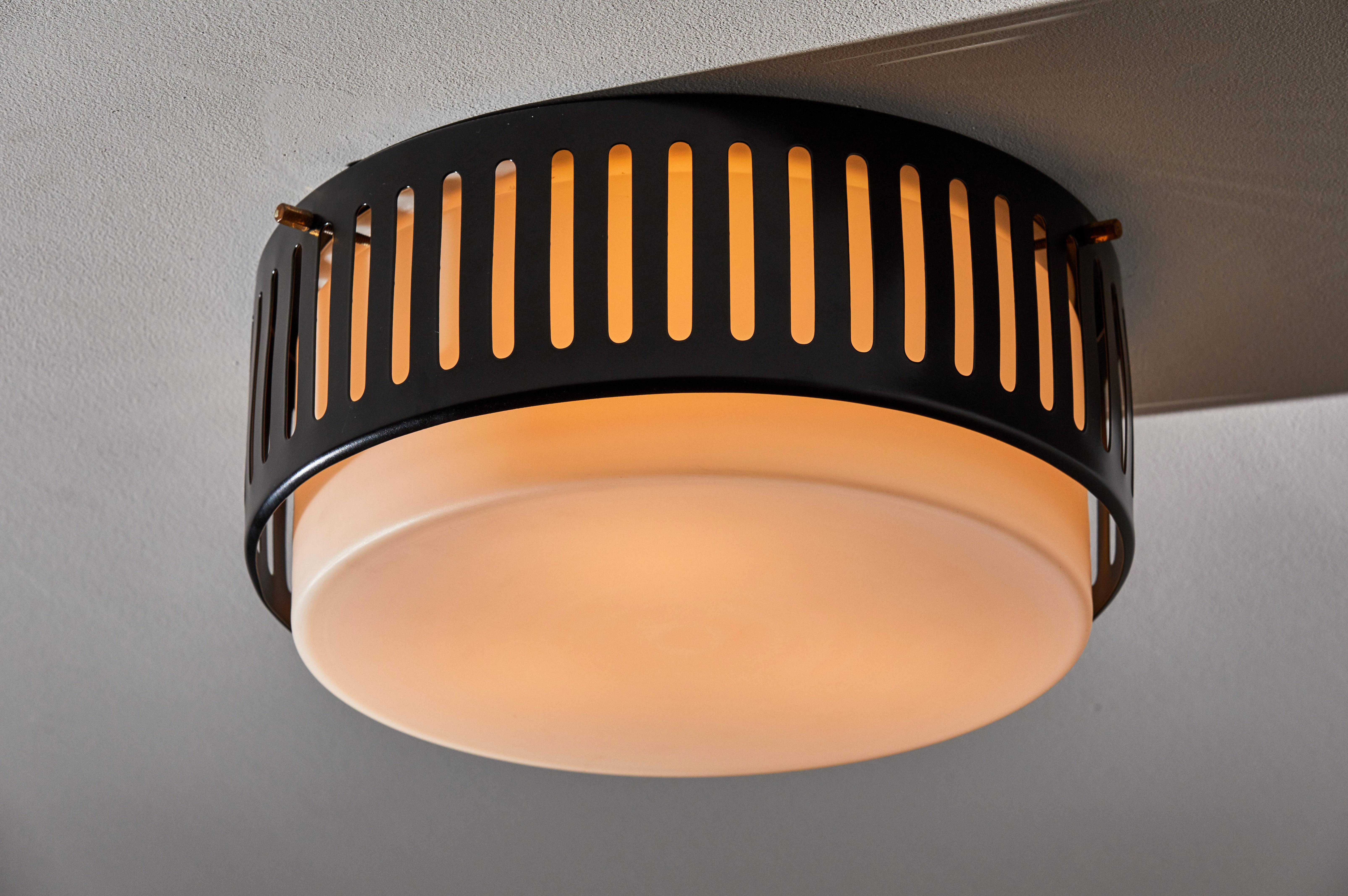 Flush mount ceiling light by Stilnovo. Designed and manufactured in Italy, circa 1950s. Rewired for US junction boxes. Brushed satin glass diffuser with enameled, perforated metal hardware. Quantity 2 available. Takes three E27 60W maximum bulbs.