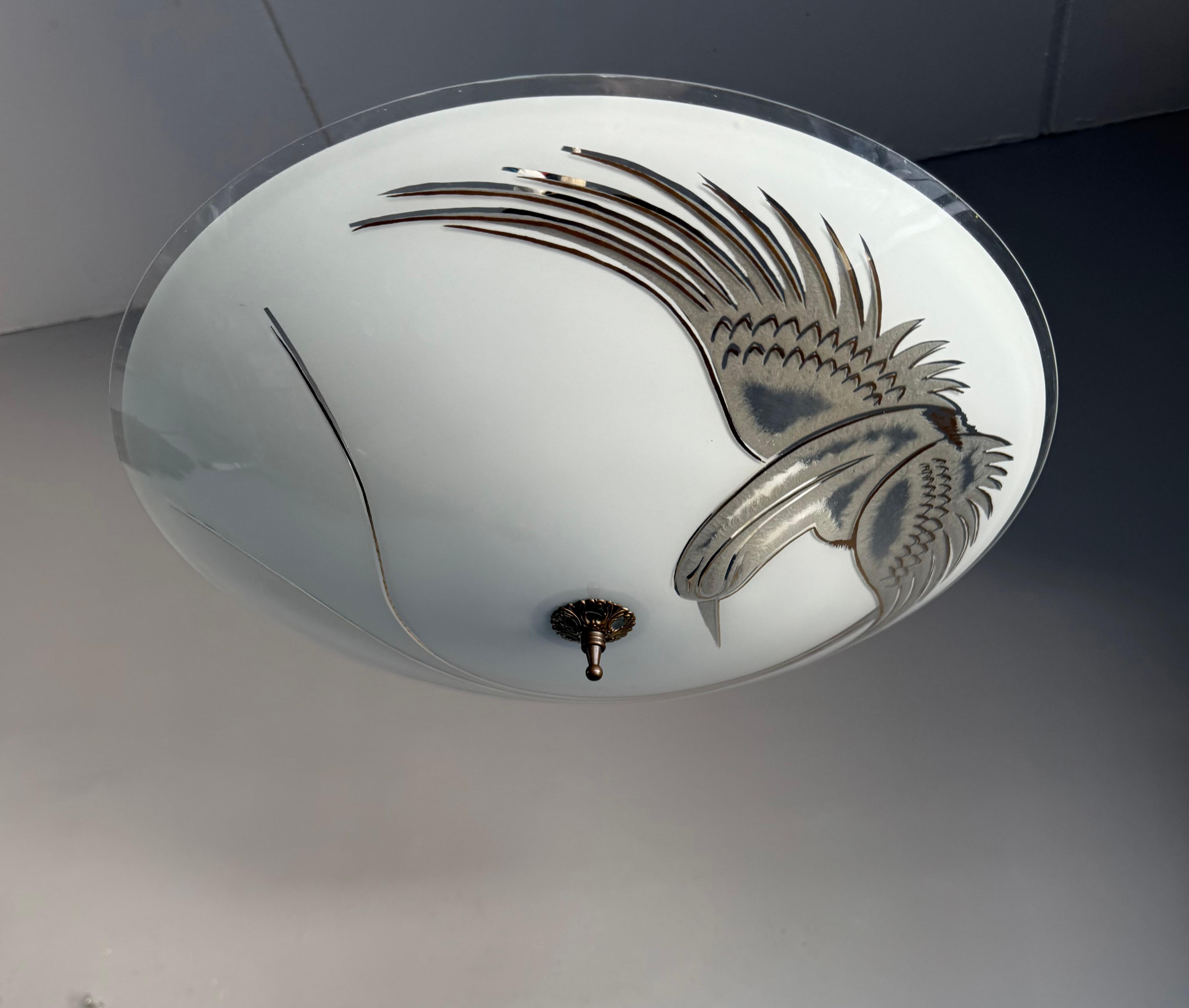 This 1950s two-light flush mount is a perfect embodiment of Mid-Century style, and finding one in such outstanding condition is a rare opportunity.

The frosted glass shade features an exquisitely etched and painted paradise bird in full flight, its