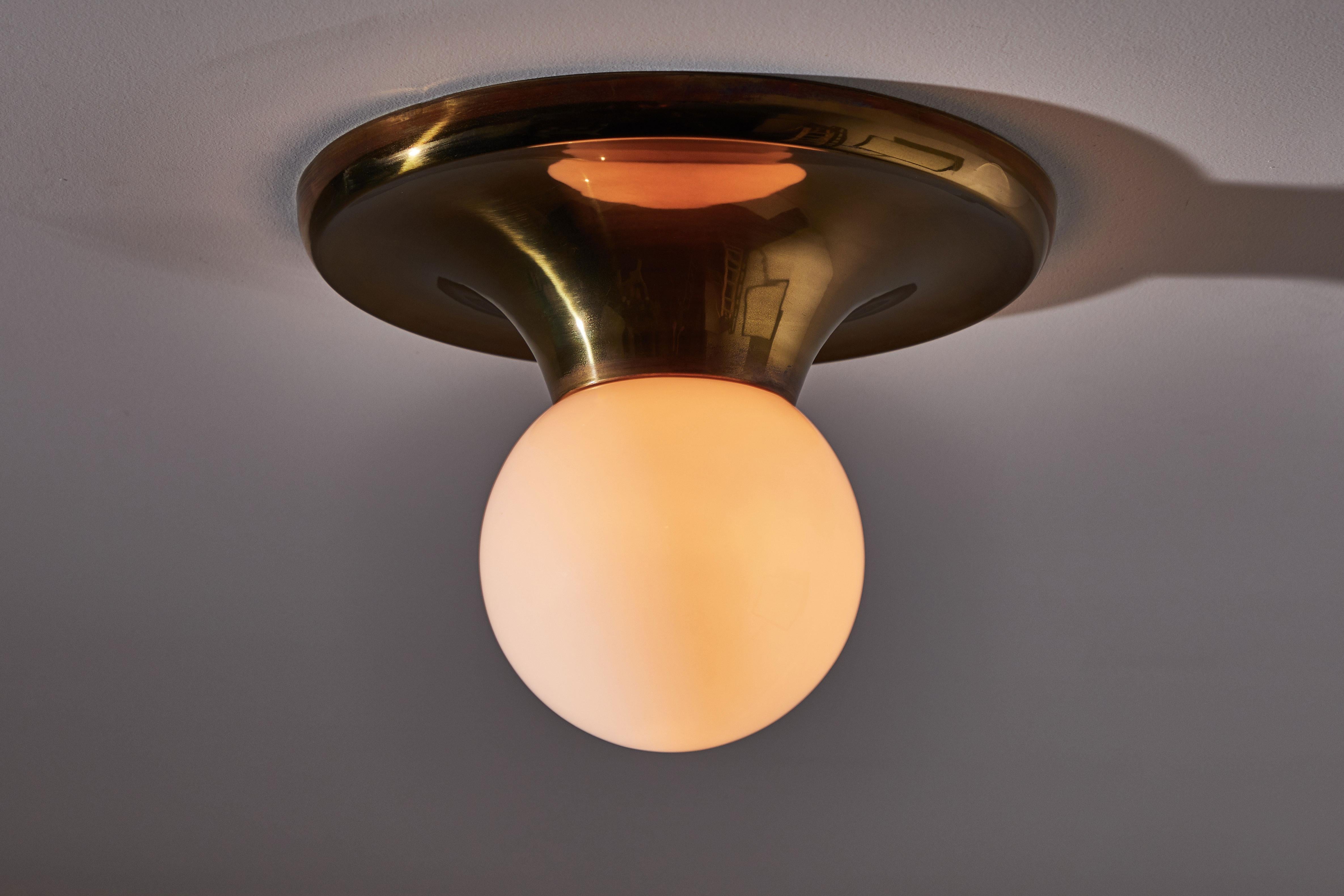 Single flush mount ceiling light by Achille & Pier Giacomo Castiglioni for Flos. Designed and manufactured in Italy, 1965. Brass and opaline glass. Rewired for US junction boxes. Each light takes one E27 100w maximum bulb. Literature: Casa Amica