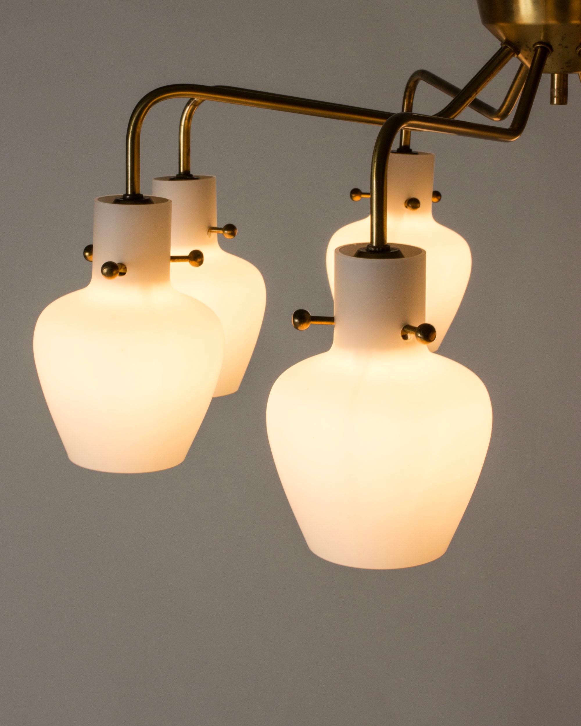 Llamativa lámpara de araña empotrada de Hans Bergström, con un fresco diseño modernista. De latón, con ocho brazos y tulipas de cristal opalino suspendidas sobre pomos decorativos.

Hans Bergström era el propietario y director creativo de la empresa