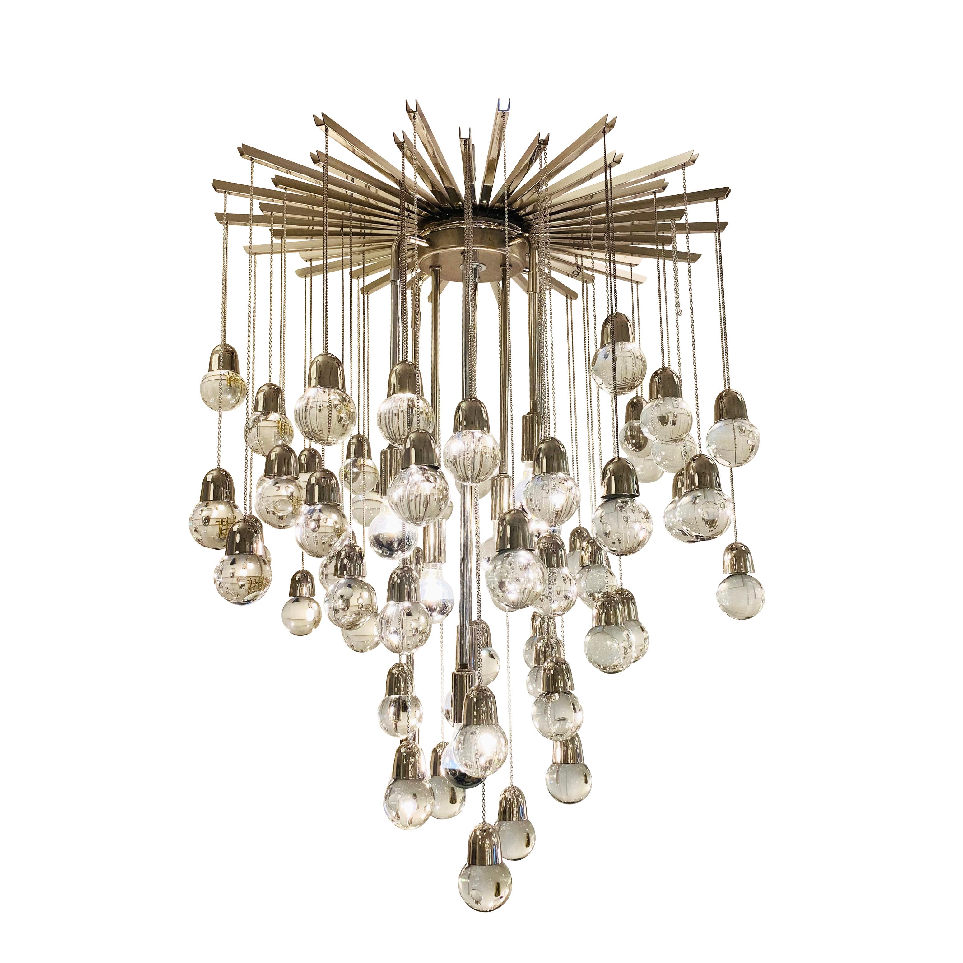 Eye-catching chandelier made with more than ninety glass spheres hanging from a star-shaped canopy. Nine stems with sockets come down from the star structure. Light bulbs are located at the same height of the spheres making them blend in.