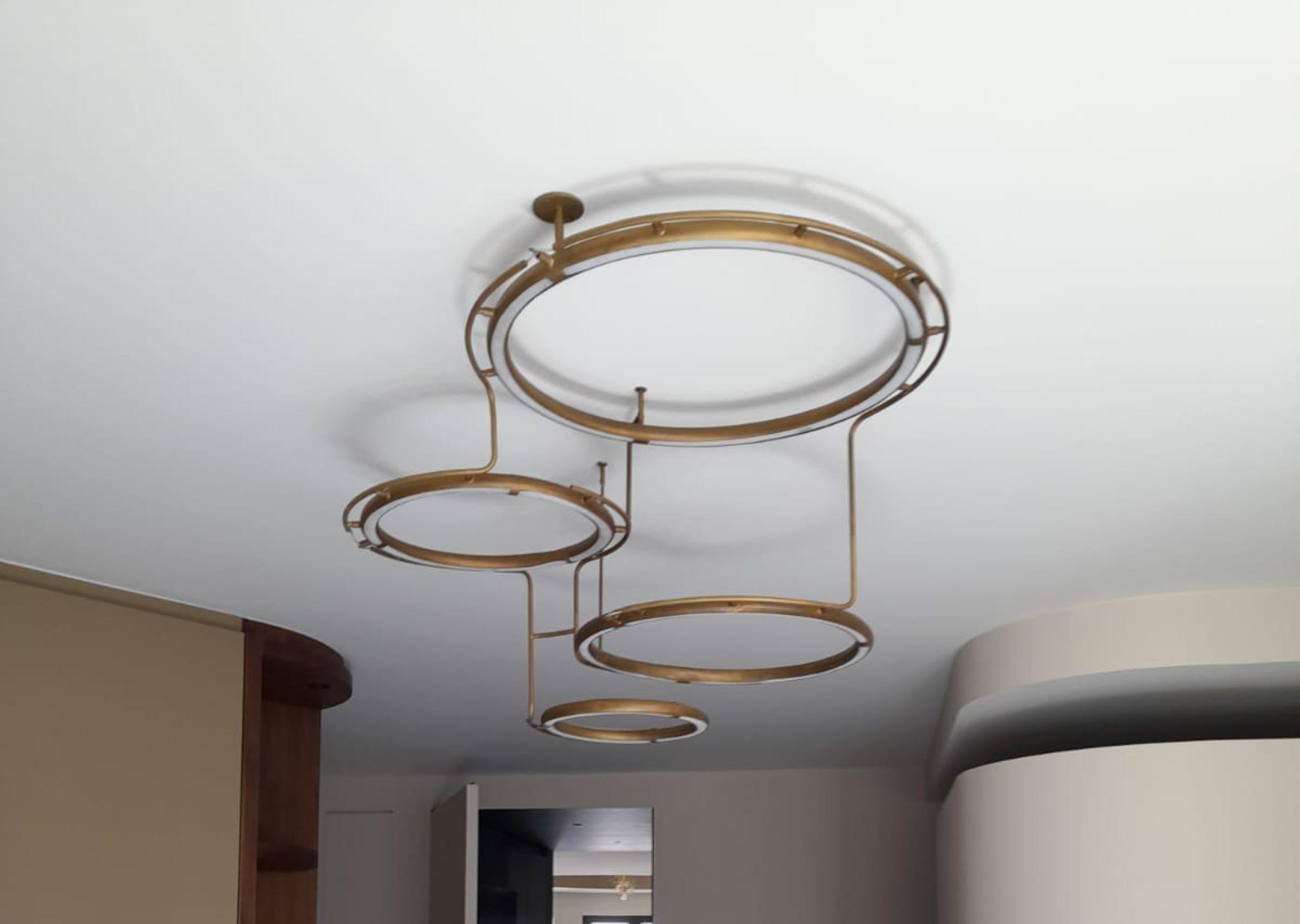 Este colgante es una construcción de 4 anillos de latón con tubos led flexibles en los anillos. Las anillas están conectadas entre sí y cuelgan una encima de la otra y una al lado de la otra. 
Medidas: Hay 1 anillo de 51 cm, 1 anillo de 41,5 cm, 1
