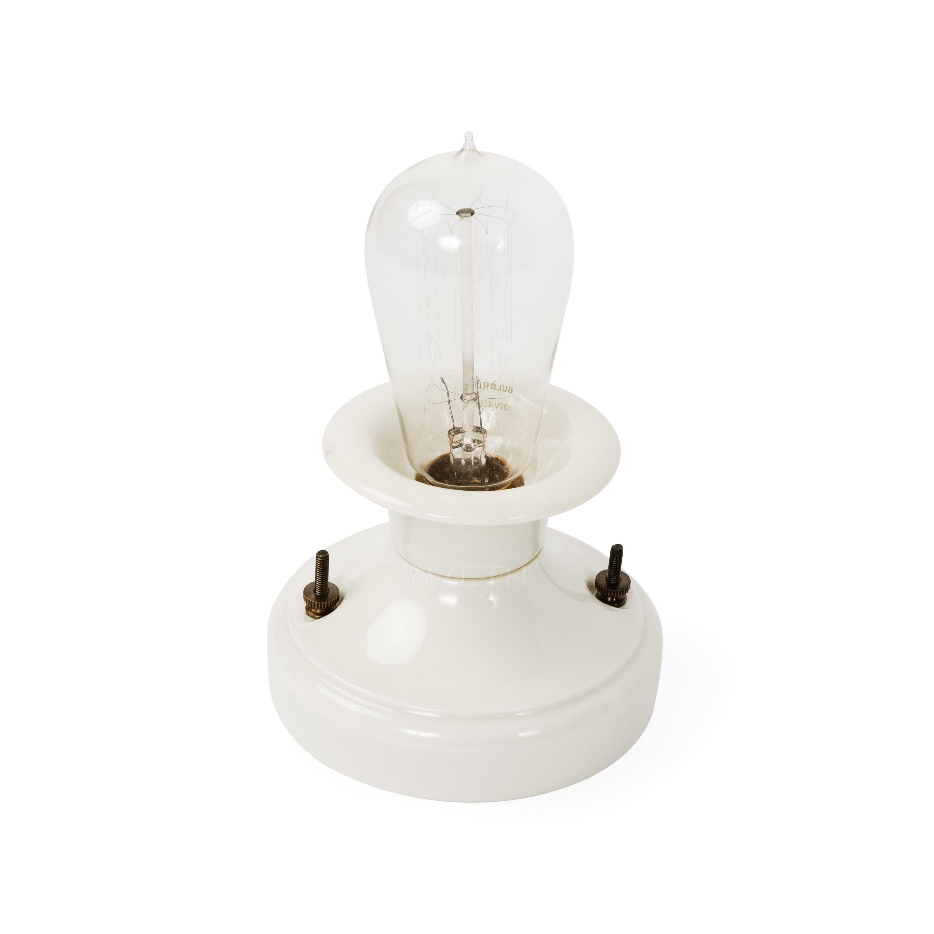 A white porcelain bowl-form wall sconce or ceiling lamp.