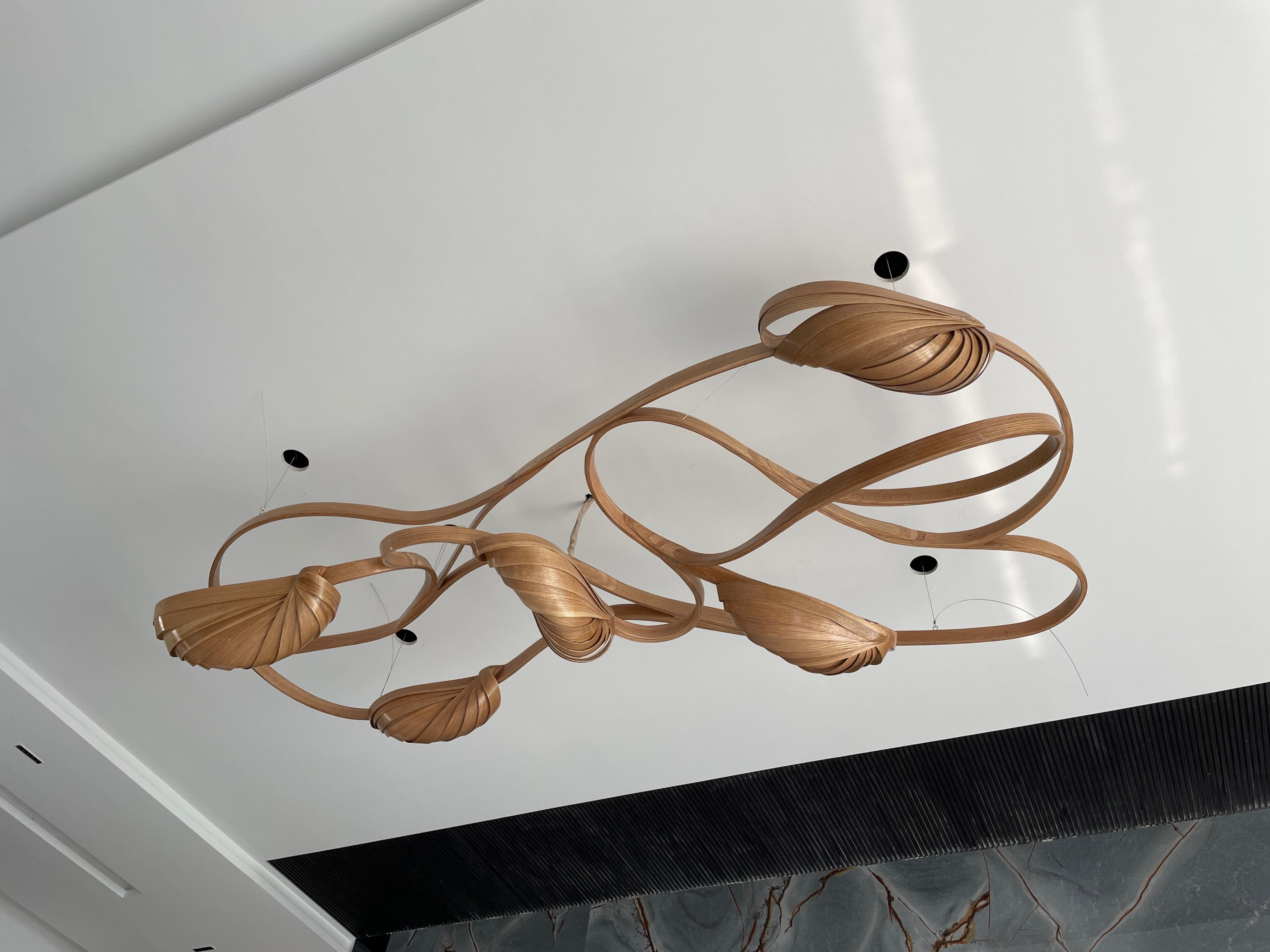The Flush Mount Light 2 - V2  sits closely on the ceiling, it has been made using solid ash wood by bending the wood. Three cocoon-like wooden structures bear the light bulbs, dispelling light from between the wooden structures.

The Vrksa Series is