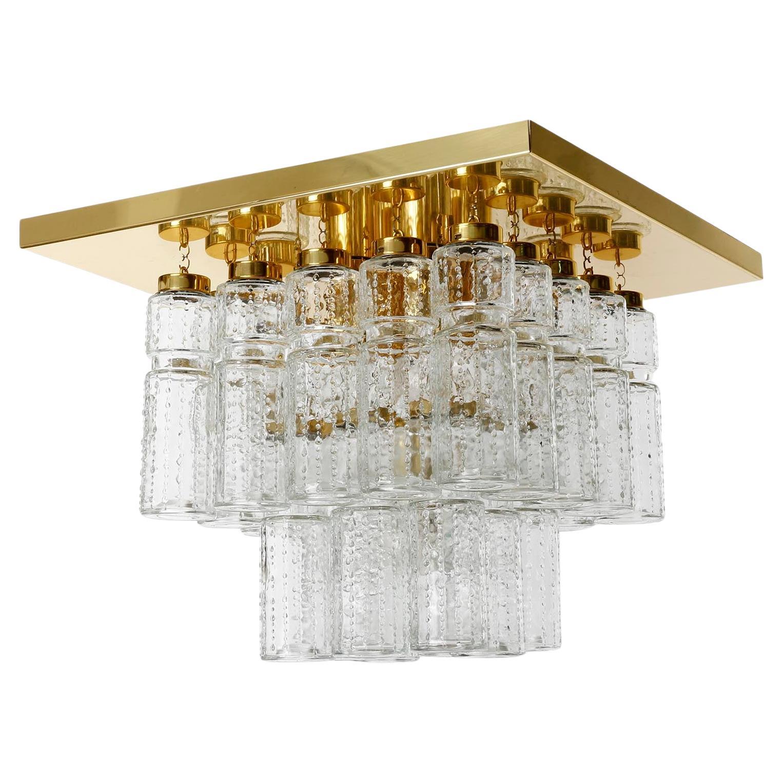 Plafonnier de style moderne du milieu du siècle, fabriqué par Glashütte Limburg, Allemagne, dans les années 1970.
Cinq lampes sont disponibles. Le prix est par lumière.
25 tubes en verre transparent texturé sont suspendus à une plaque de plafond