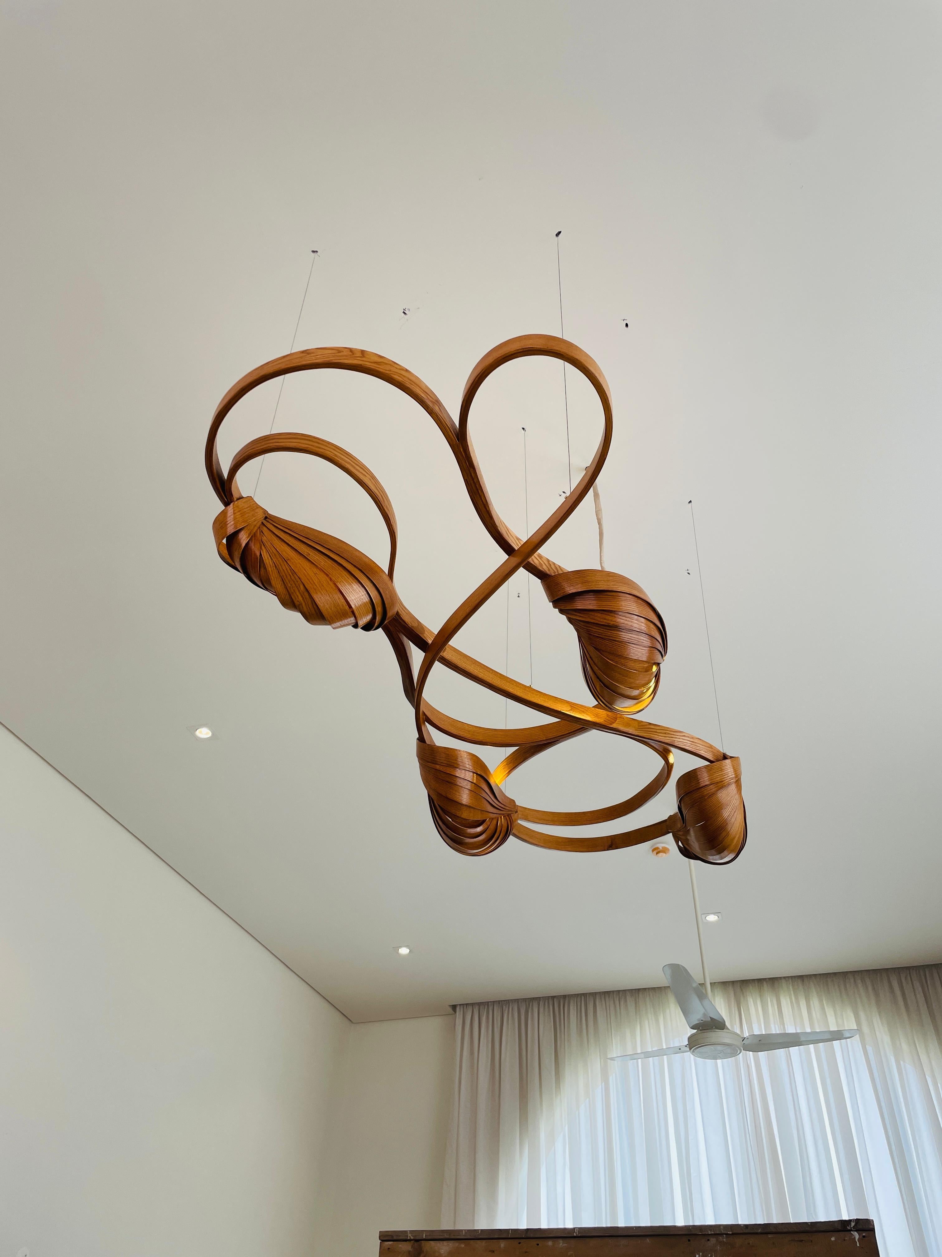 This variation of the Flush Mount Light No. 2 has an extra lighting pod installed; making a total of four lighting pods.

It sits closely on the ceiling, it has been made using solid ash wood by bending the wood. Two cocoon-like wooden structures
