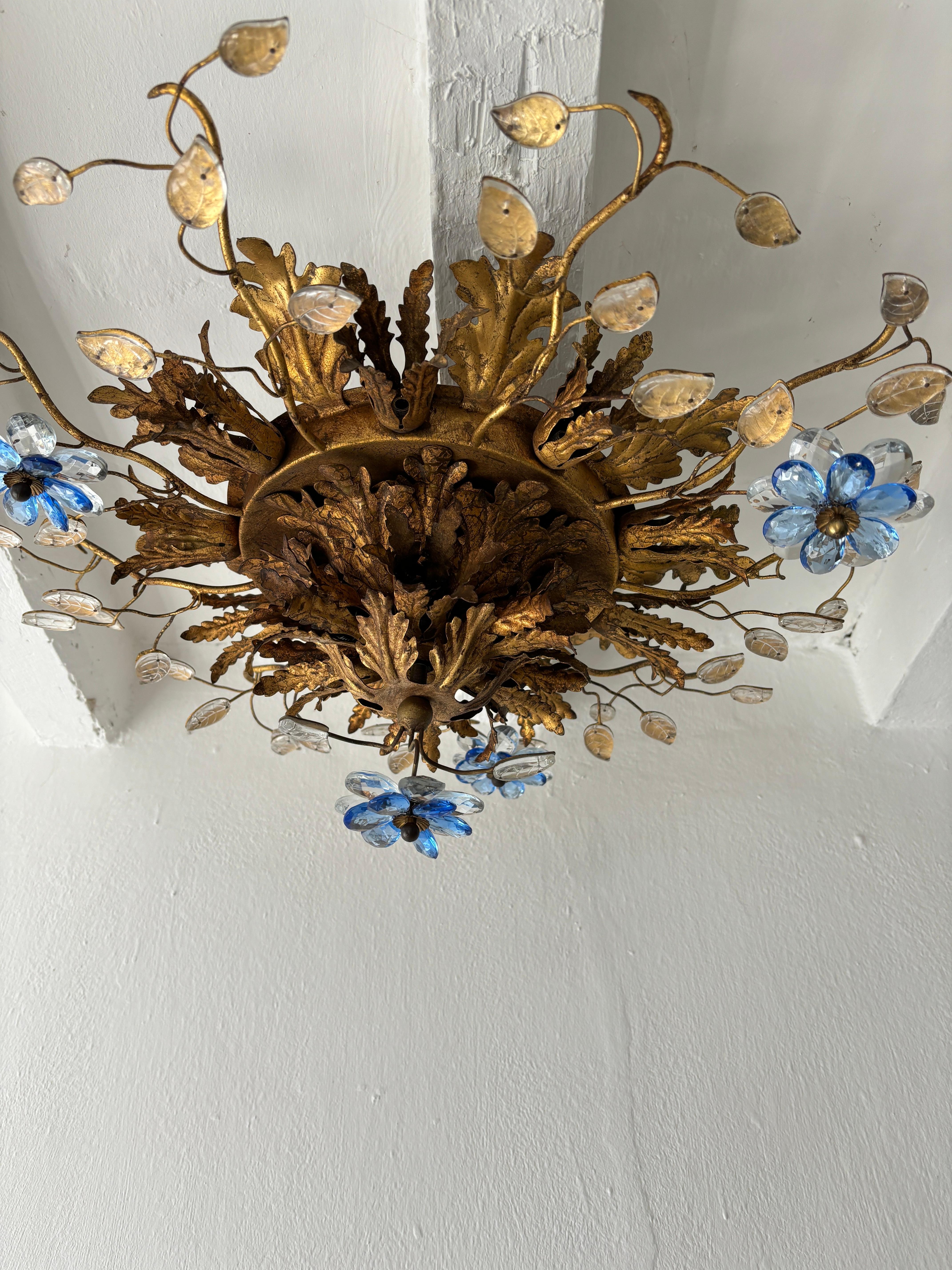 Housing 15 lights. Will be newly rewired free of charge with certified UL US sockets for the USA and appropriate sockets for all other countries and ready to hang. Gold tole with perfect patina. Double crystal prism flowers in clear and blue. Signed