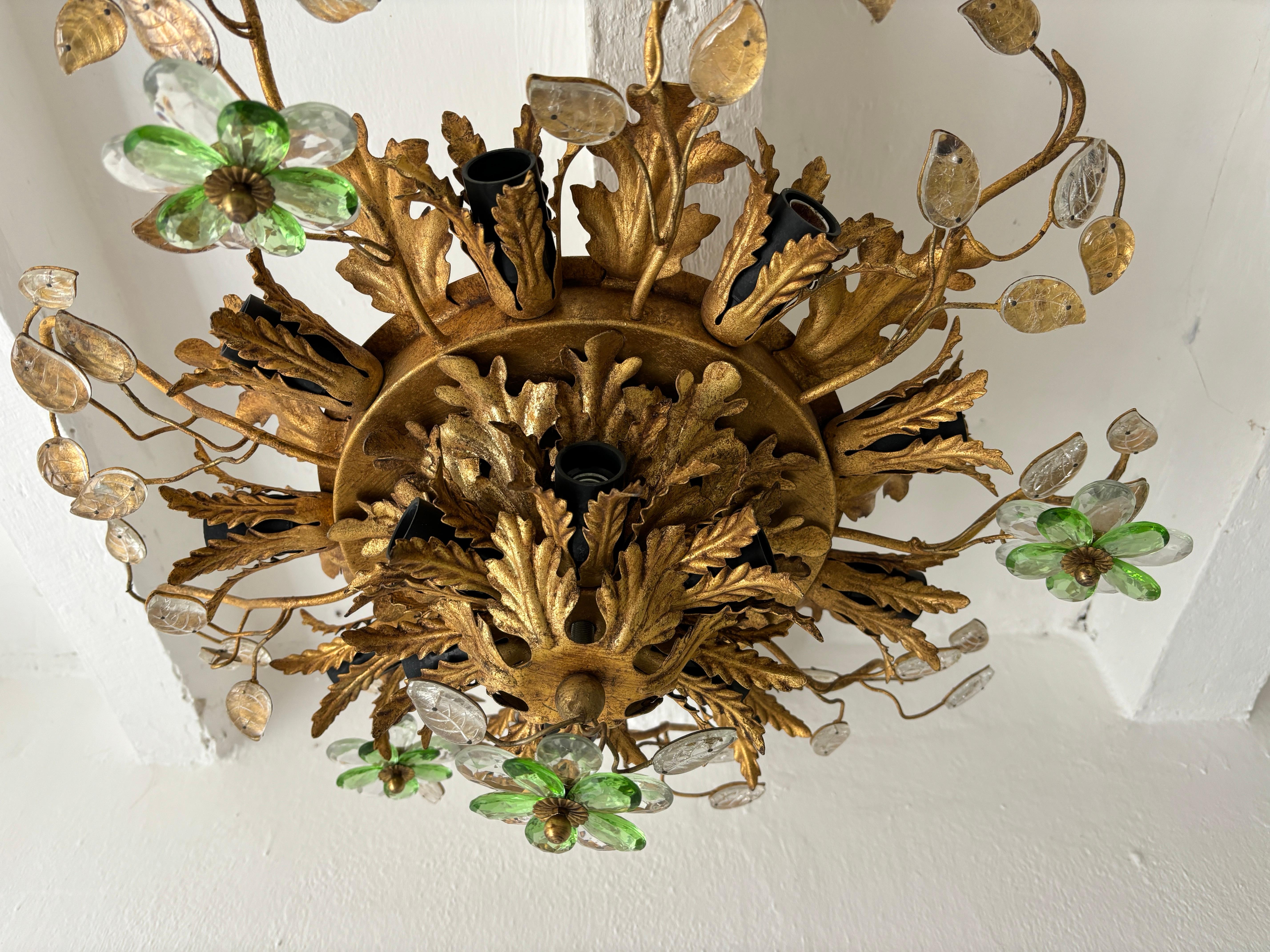 Housing 15 lights. Will be rewired free of charge with certified UL US sockets for the USA and appropriate sockets for all other countries and ready to hang. Gold tole with perfect patina. Adorning double crystal prisms in clear and green flowers