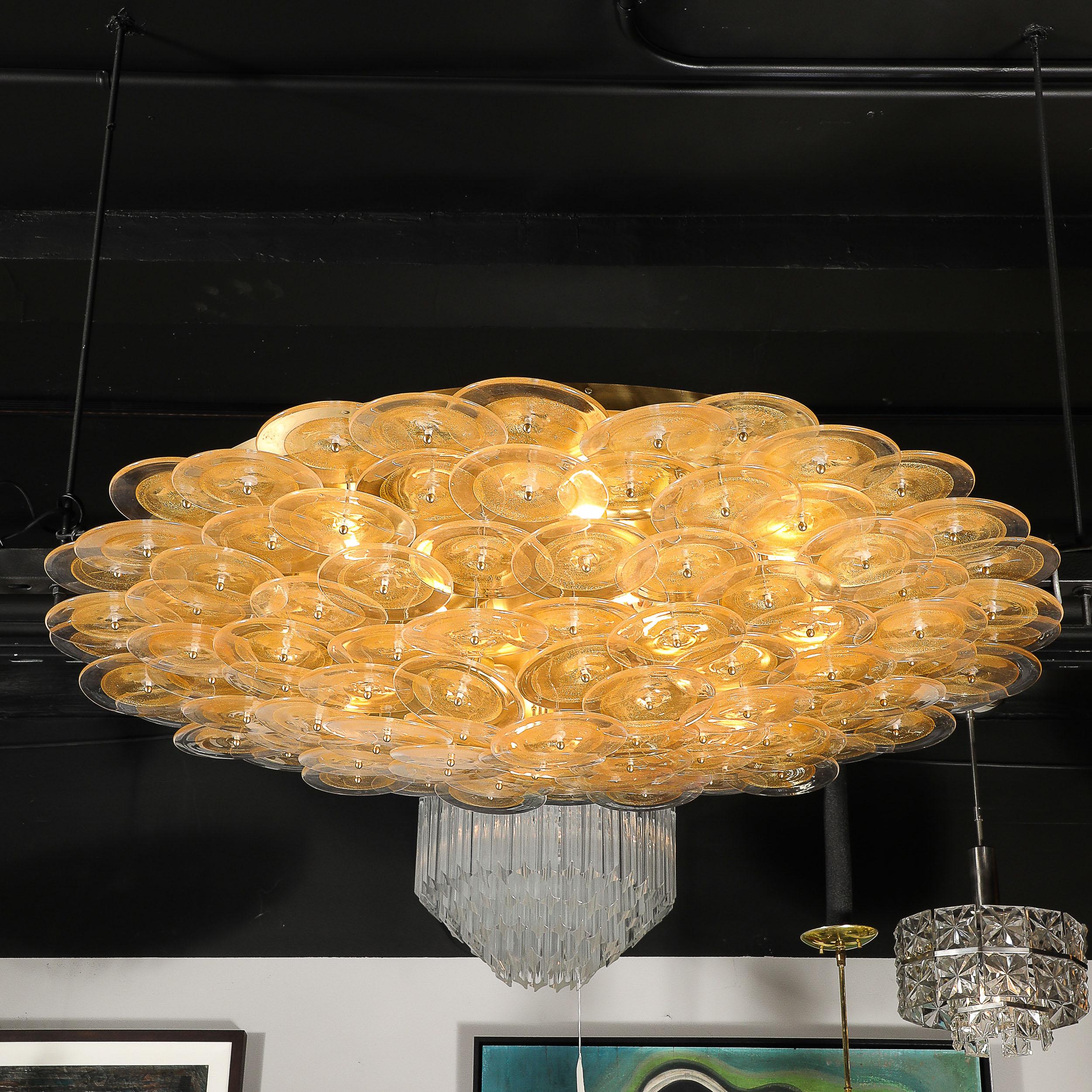 Lustre encastré avec disques en verre clair et or de Murano soufflés à la main. Ce lustre encastré se compose d'un ensemble de nombreux disques en verre clair et doré de Murano, soufflés à la main, qui intègrent chacun une texture centrale opaque