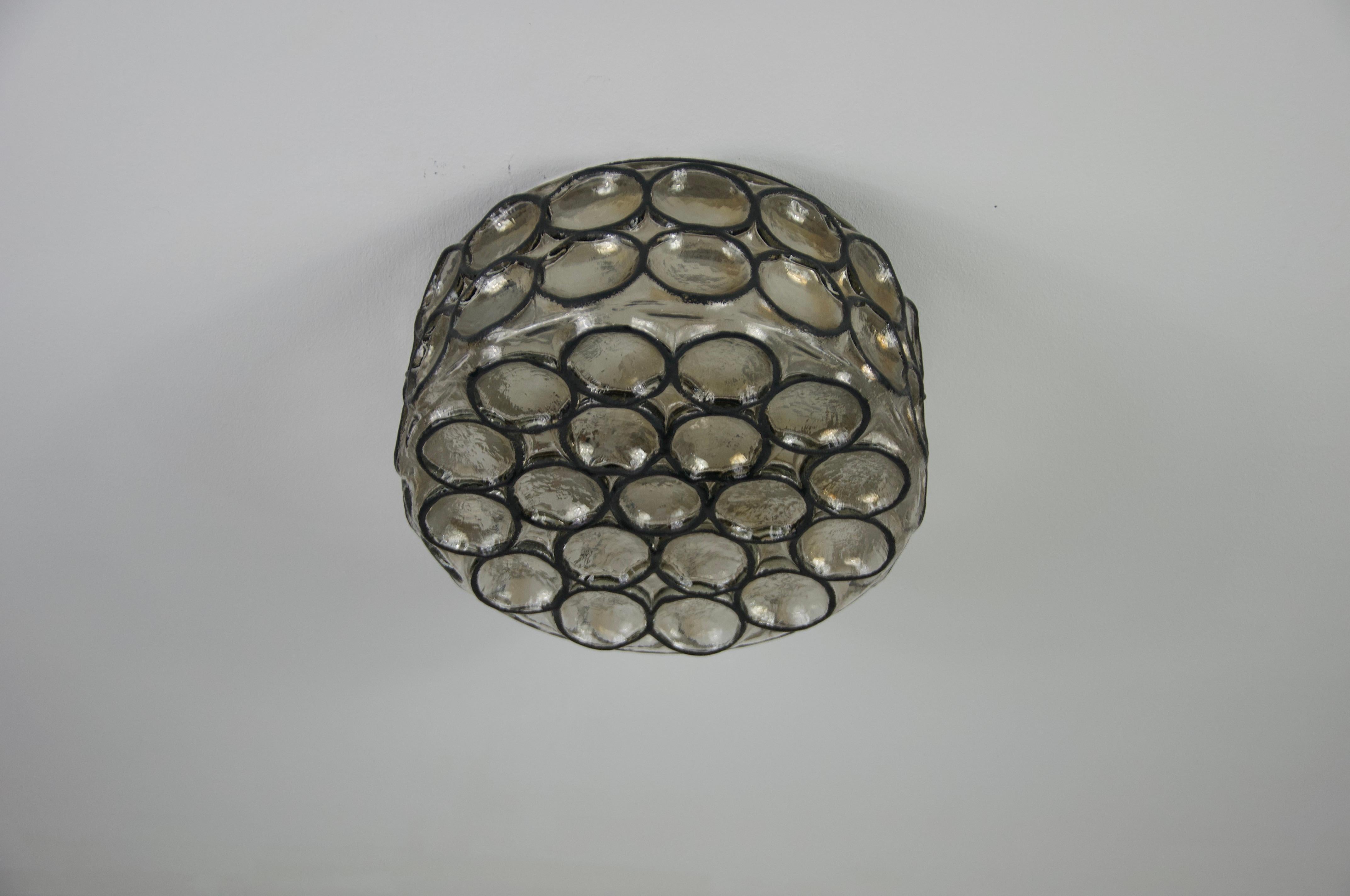 This distinguished Limburg flush mount, crafted in the 1960s, exemplifies the superior quality and precision of German workmanship. The lamp is elegantly designed with a iron design glass shade, which is securely rotated into the frame, showcasing