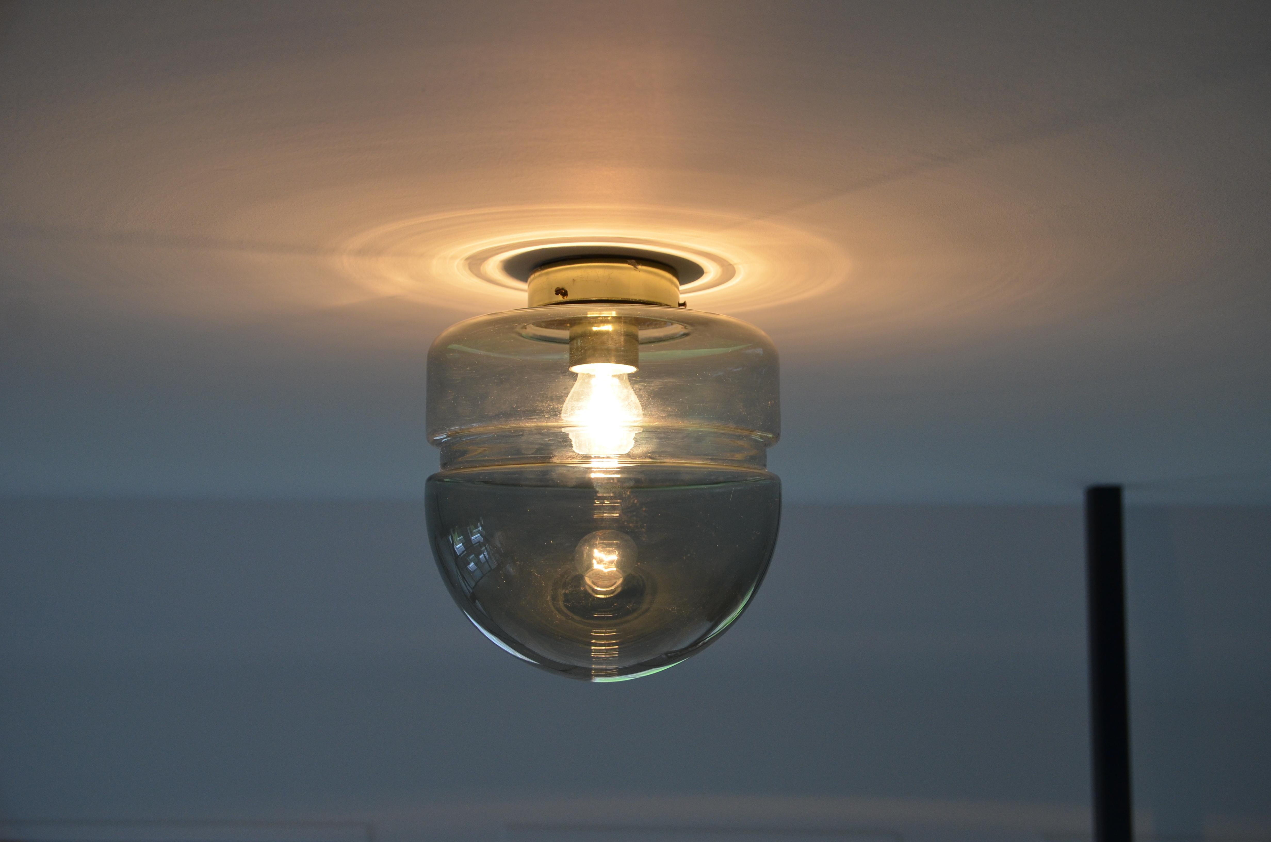Simple, round ceiling light in grey smoked glass. The glass bulb is attached to a brass colored fixture. Can also be used as wall light.