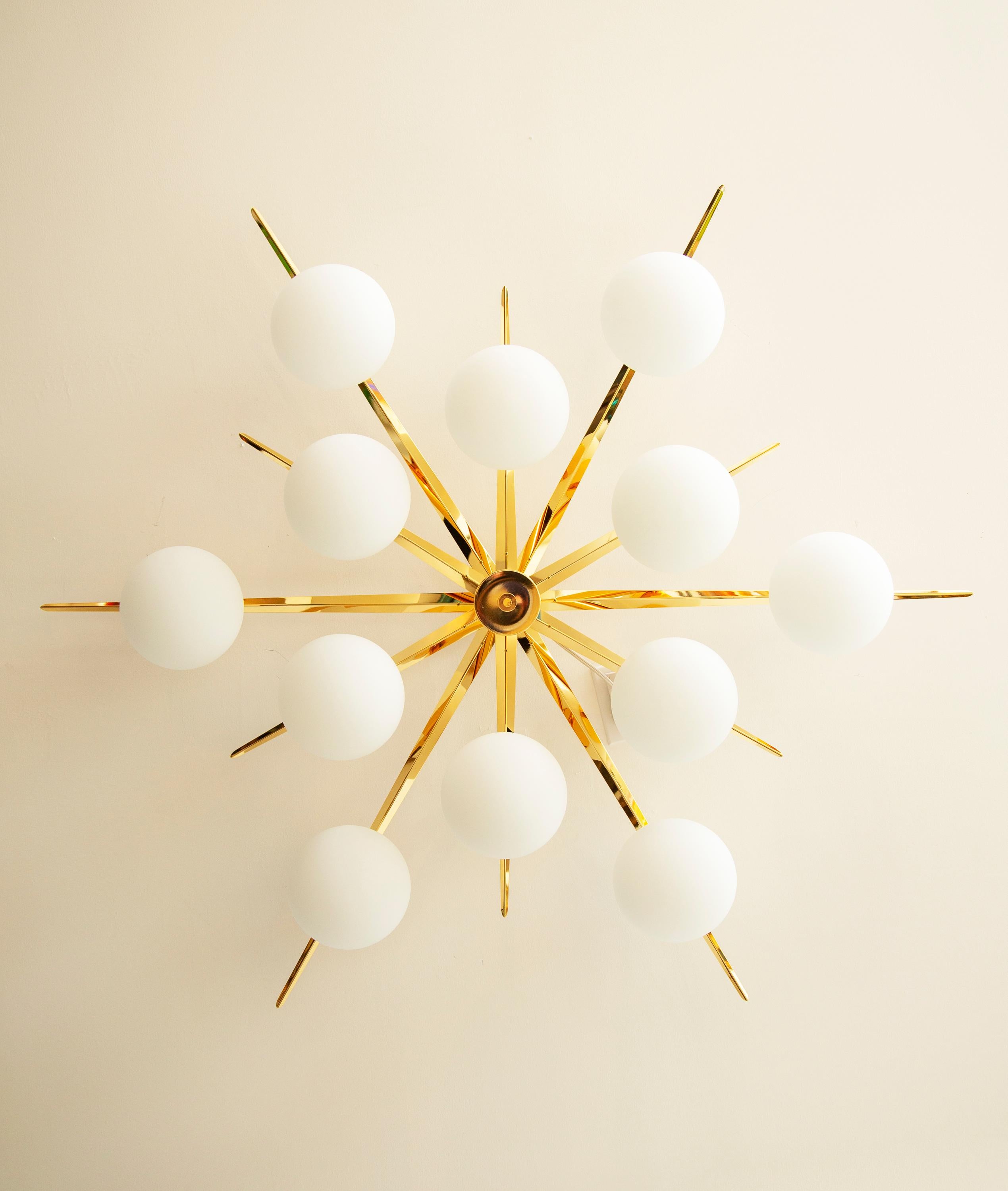Contemporary flush mount starburst ceiling light in polished brass and matte glass
Features 12 oblong shape matte globes
Stunning design from all angles

Wattage per light: 25
Total wattage: 300
Bulb type: Candelabra size bulbs, 25 Watt recommended