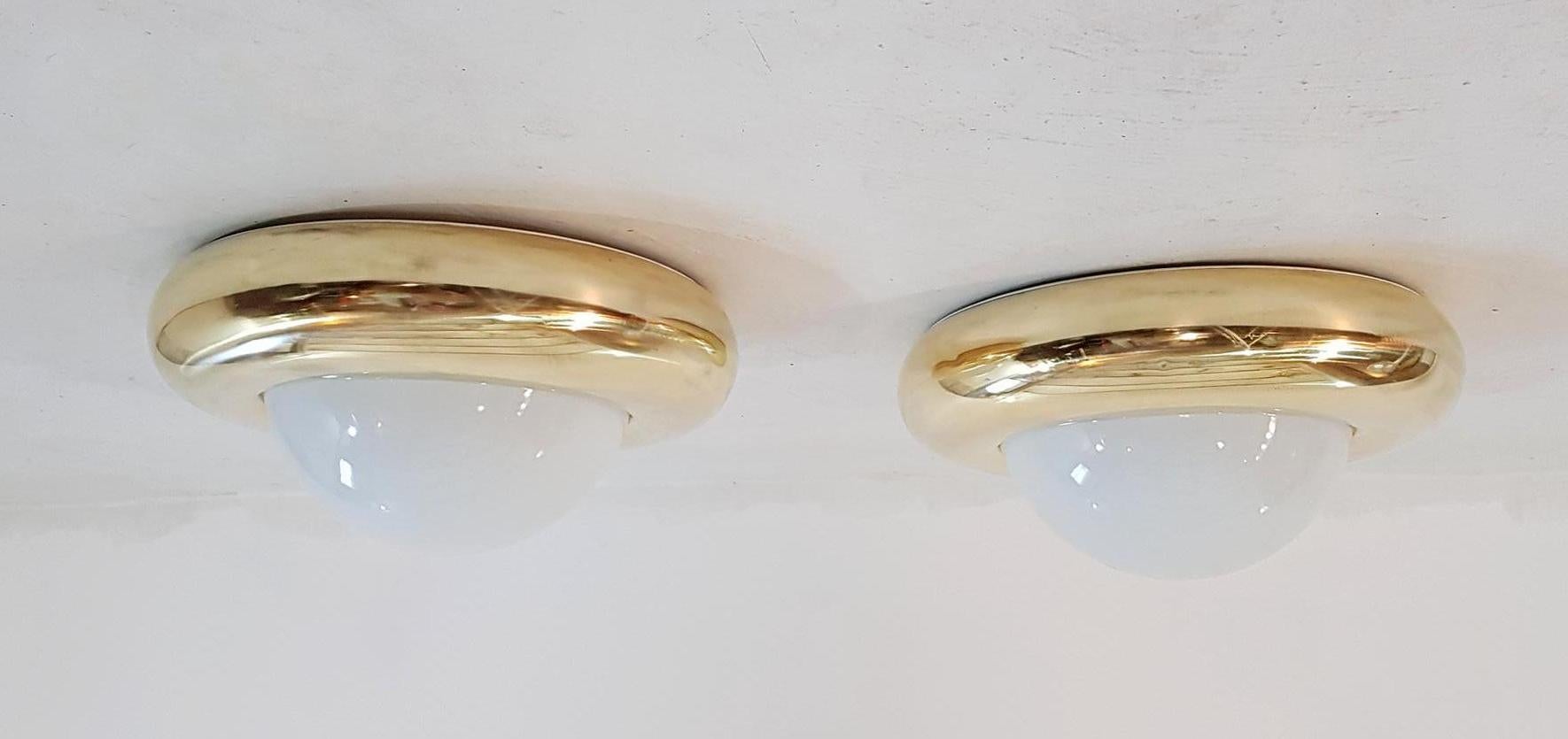 A large pair of lamps that can be used as flush mounts or wall sconces in brass and opaline glass. Each light takes one E27 bulb. The brass has been professionally rebuffed. 

 
