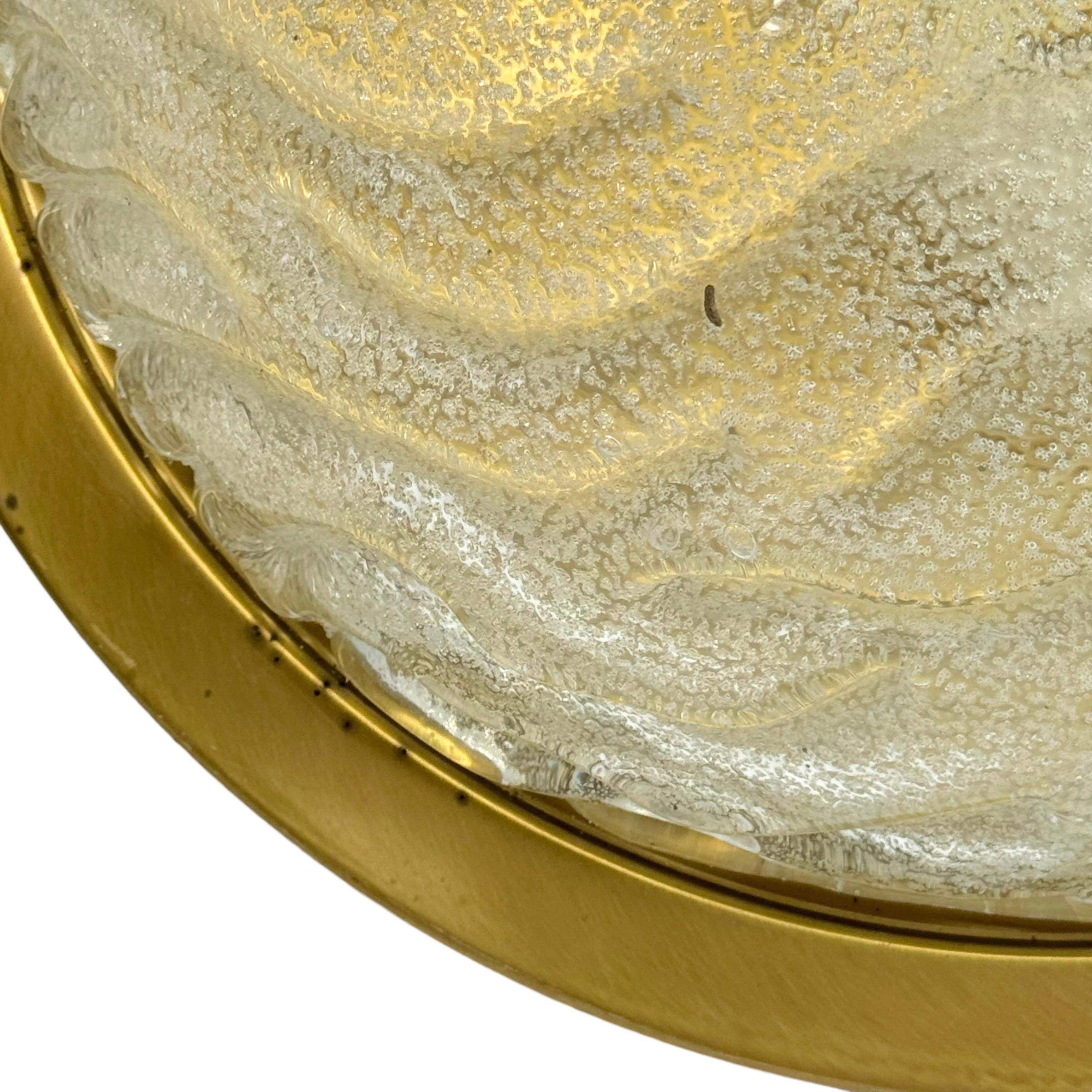 A beautiful flush mount by German manufacturer Fischer Leuchten. The heavy glass element is supported by a burnished brass plate with two light sources. Beautiful wave clear glass on a metal fixture. The Fixture requires two European E27 / 110 Volt