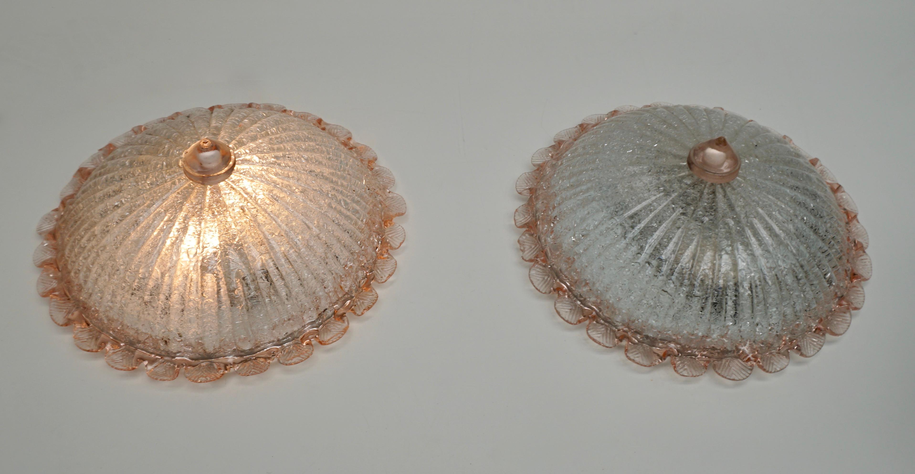 Two elegant hand blown Murano glass flushmount by Barovier & Toso. Mounted on a white frame. With pink, salmon and clear colored glass. The textured glass refract light beautifully. The flush mount fills the room with a soft, warm and welcoming
