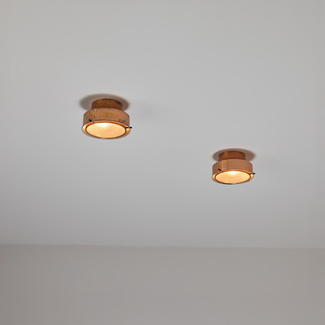 L'involucro in rame è abbinato a un diffusore con fondo in vetro a scaglie incrociate. Ogni lampada è dotata di un doppio attacco E14, adattato agli Stati Uniti. Si consiglia una lampadina da 25-60w max o un LED equivalente. Venduto singolarmente.