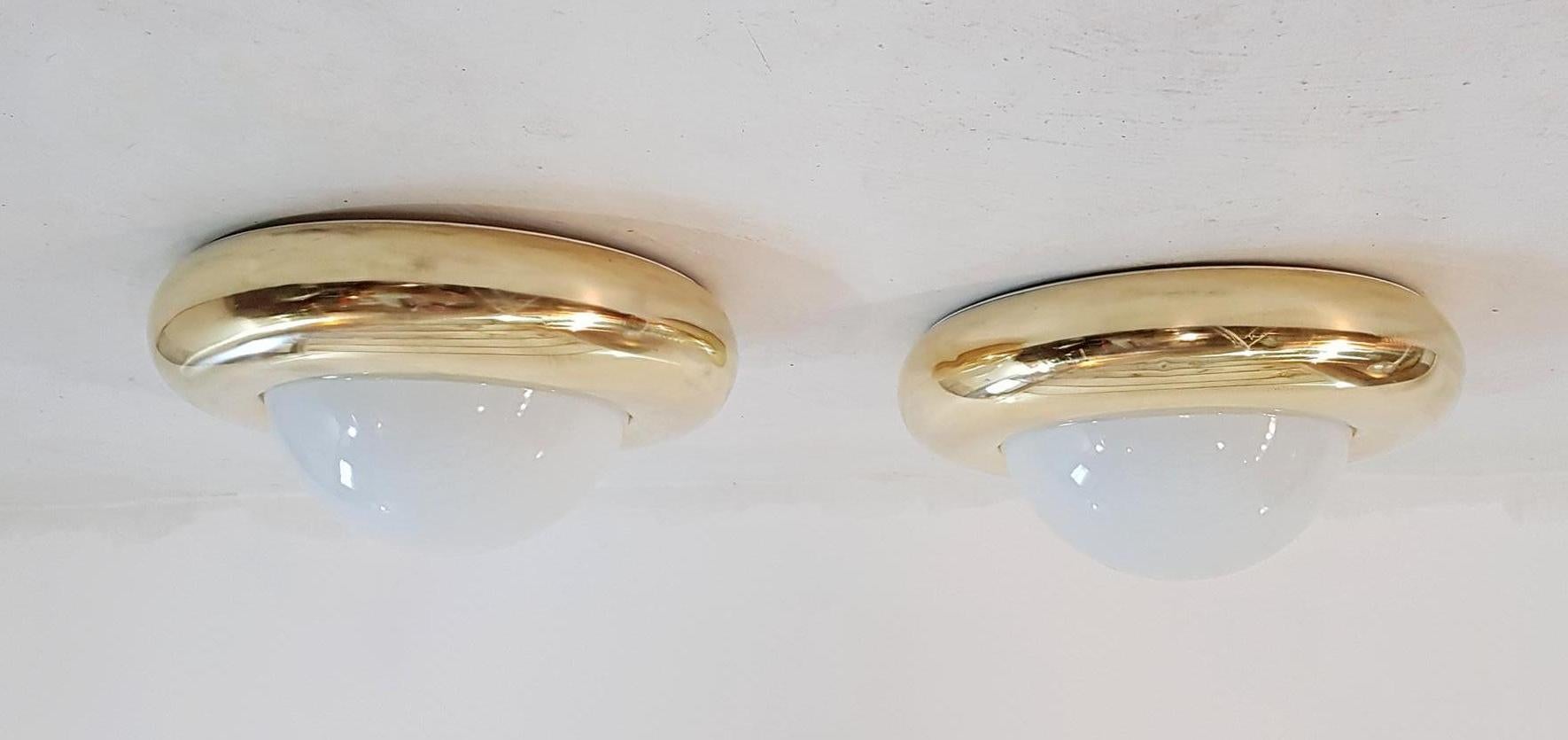 A large pair of lamps that can be used as flushmounts or wall sconces in brass and opaline glass. Each light takes one E27 bulb. The brass has been professionally rebuffed.

  