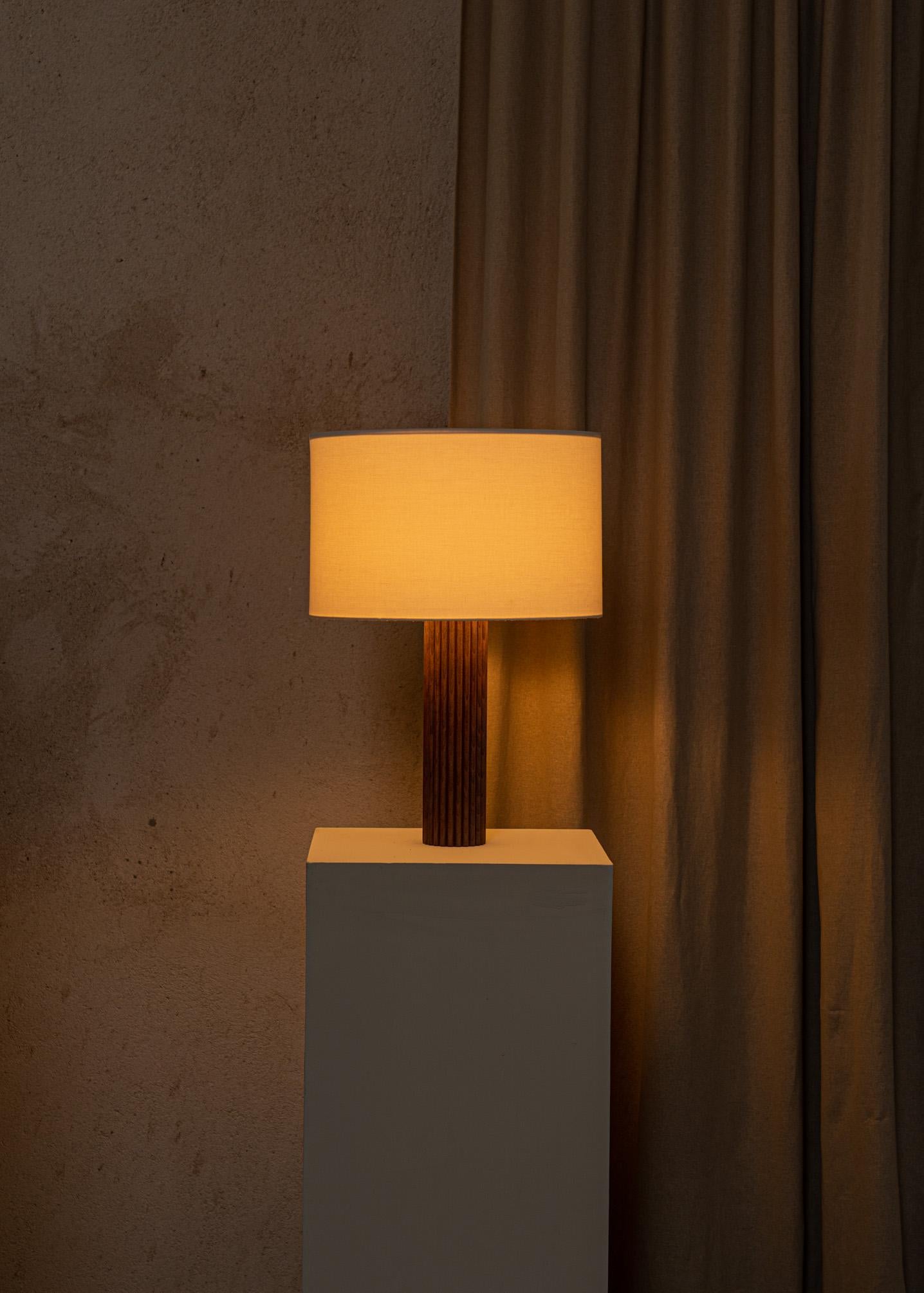 A fine ribbed column and our signature cotton drum lampshade makes the Flutita table lamp an exceptional and timeless piece. A selection of natural marble and solid wood to choose from for your interior.