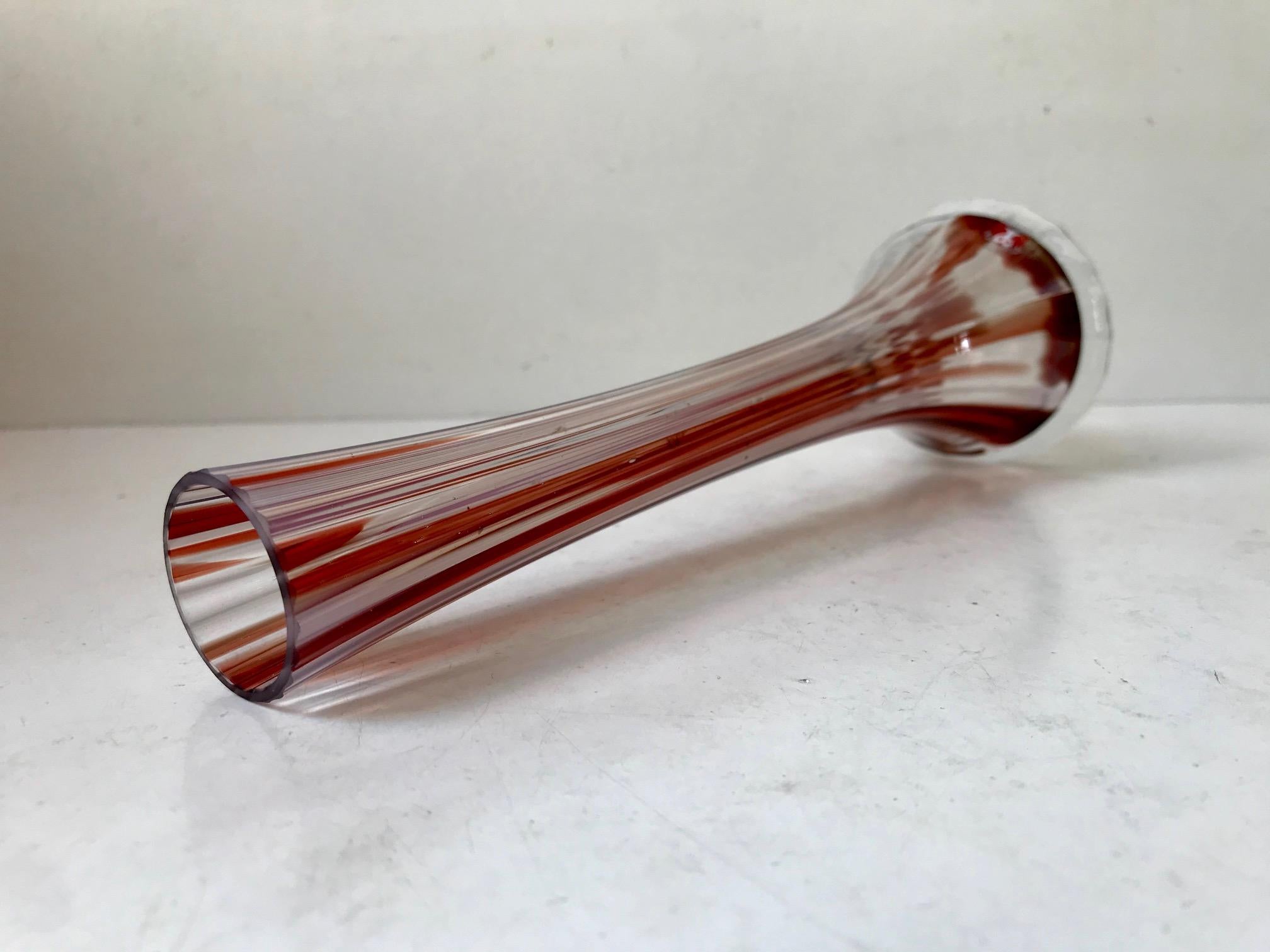 A hand sculpted clear glass vase with red stripes and vertical ribbings. Designed and made at Studiolasi in Finland, circa 1970. Measurements: H 25.3, D 8/3 cm.