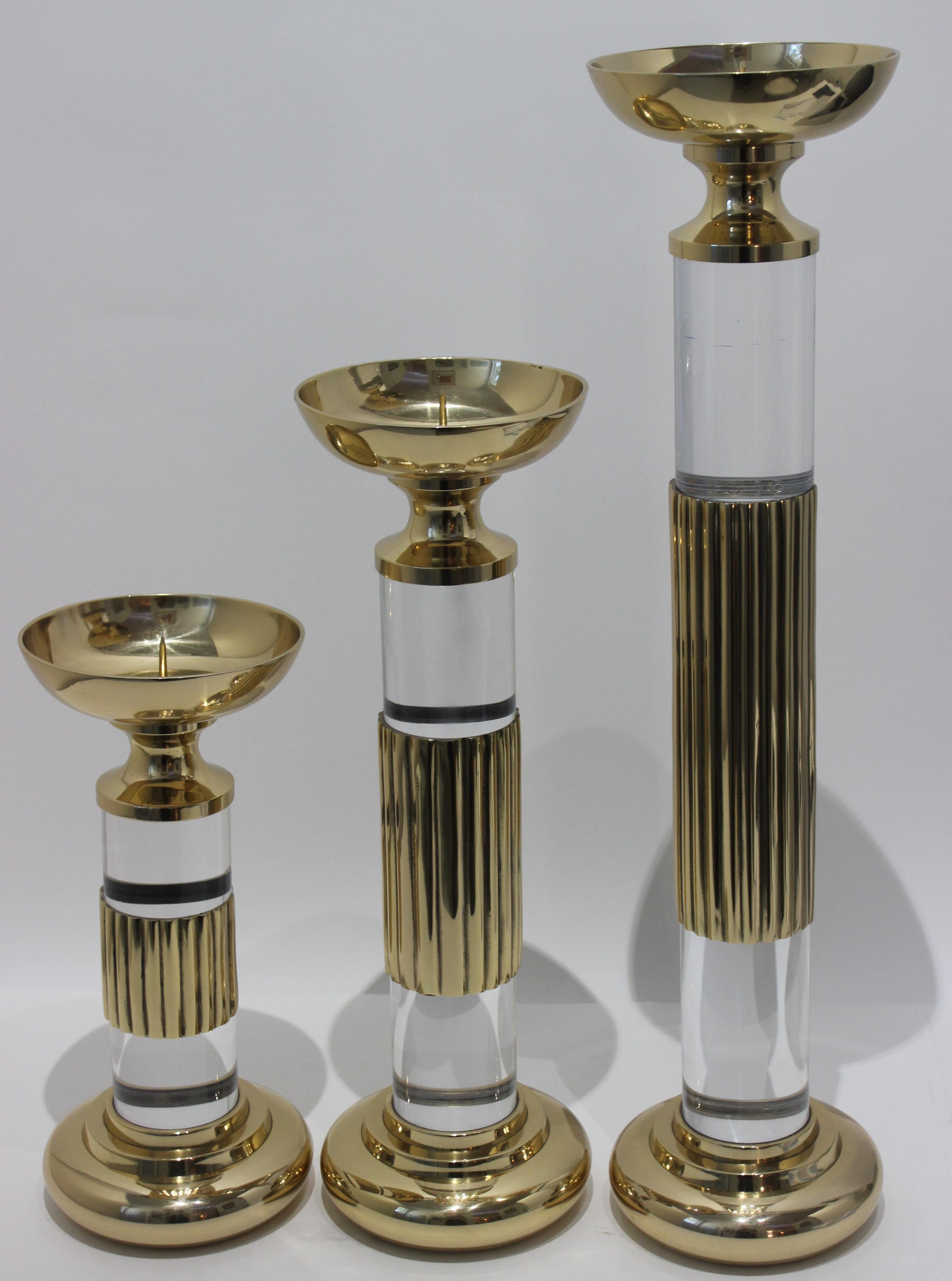 This stylish set of candlesticks date to 1987 and were fabricated by Dolbi Cashier in polished brass and Lucite. These have been professionally polished February 2020.

Note: Dimensions of tallest piece 23.63