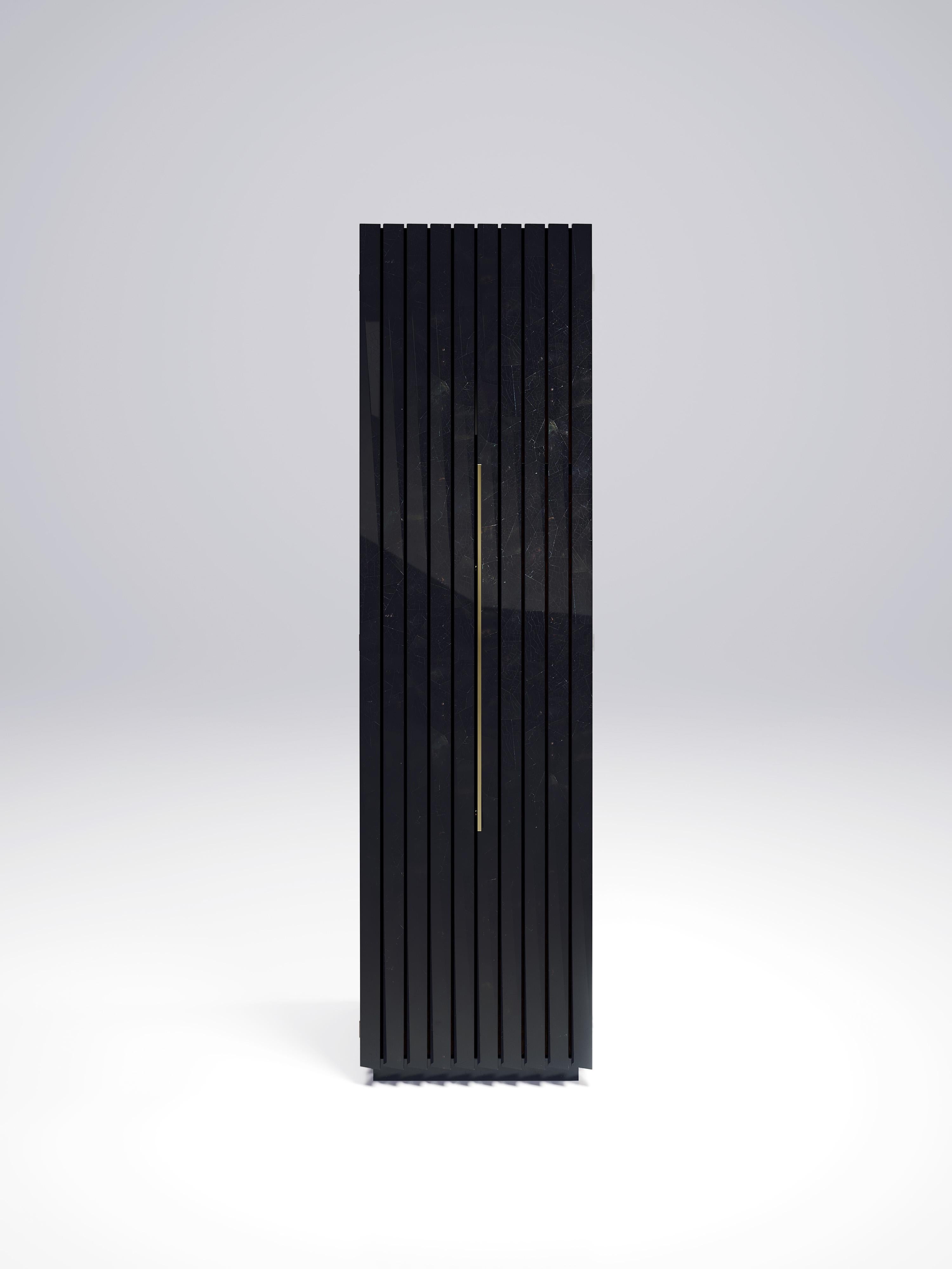 The fluted cabinet by R & Y Augousti is a sleek and geometric design. The black pen shell inlaid piece provides great utility while retaining a striking aesthetic with the incredible hand craved fluted details. This piece can be used as a bar