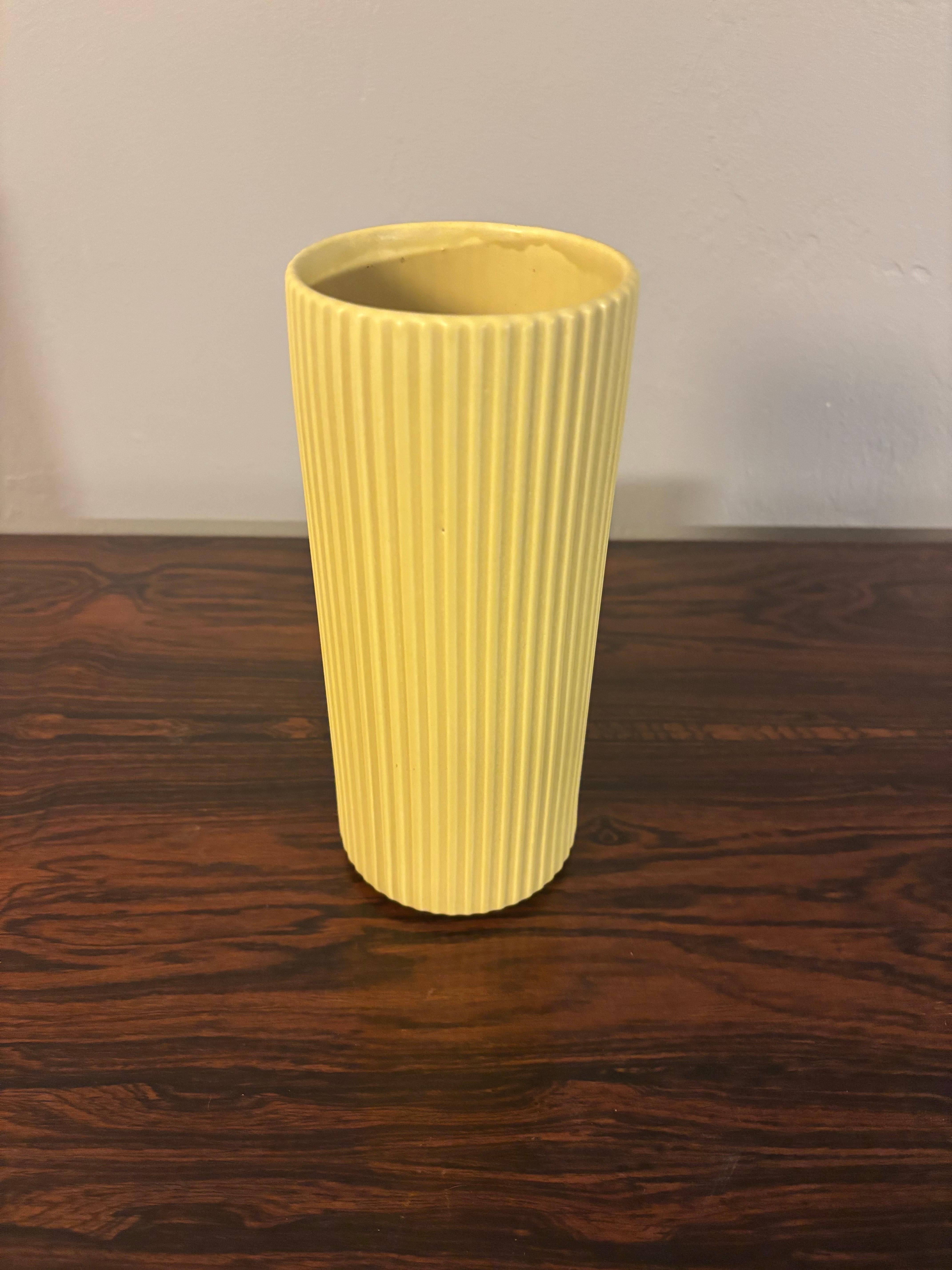 Bellissimo vaso realizzato da Arabia of Finland. Realizzato con perizia e in ottime condizioni. Di colore giallo pastello, ha una struttura scanalata con linee verticali pulite. 

Il vaso è 
Alto 8 pollici
3,33
