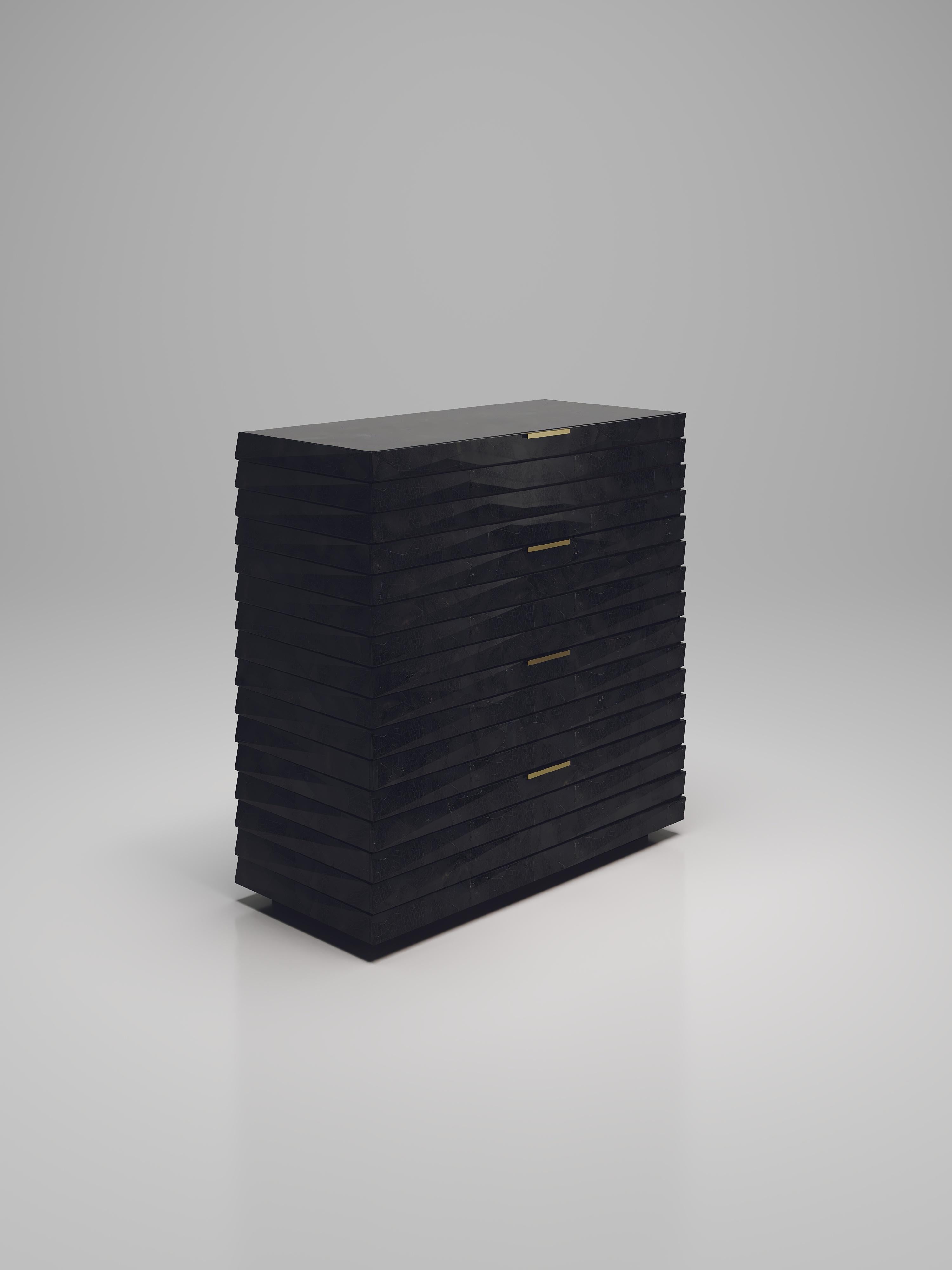 The fluted chest of drawers by R & Y Augousti is a sleek and geometric design. The black pen shell inlaid piece provides great utility while retaining a striking aesthetic with the incredible hand craved fluted details. This piece includes a total