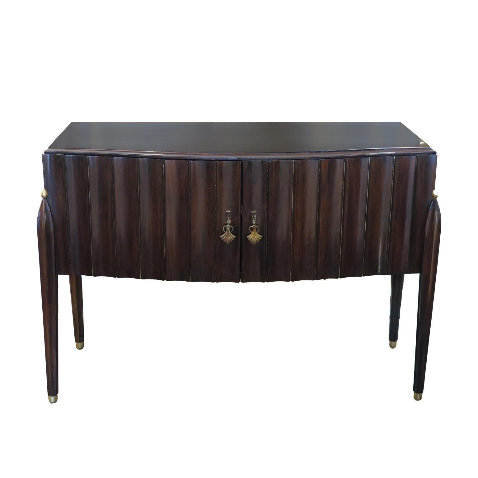 Early mid-century console with an espresso stained mahogany with beautiful fluted detailing along facade and sides. Four ribbed tapered legs support the delicate frame. The original brass hardware adds the finishing touch.