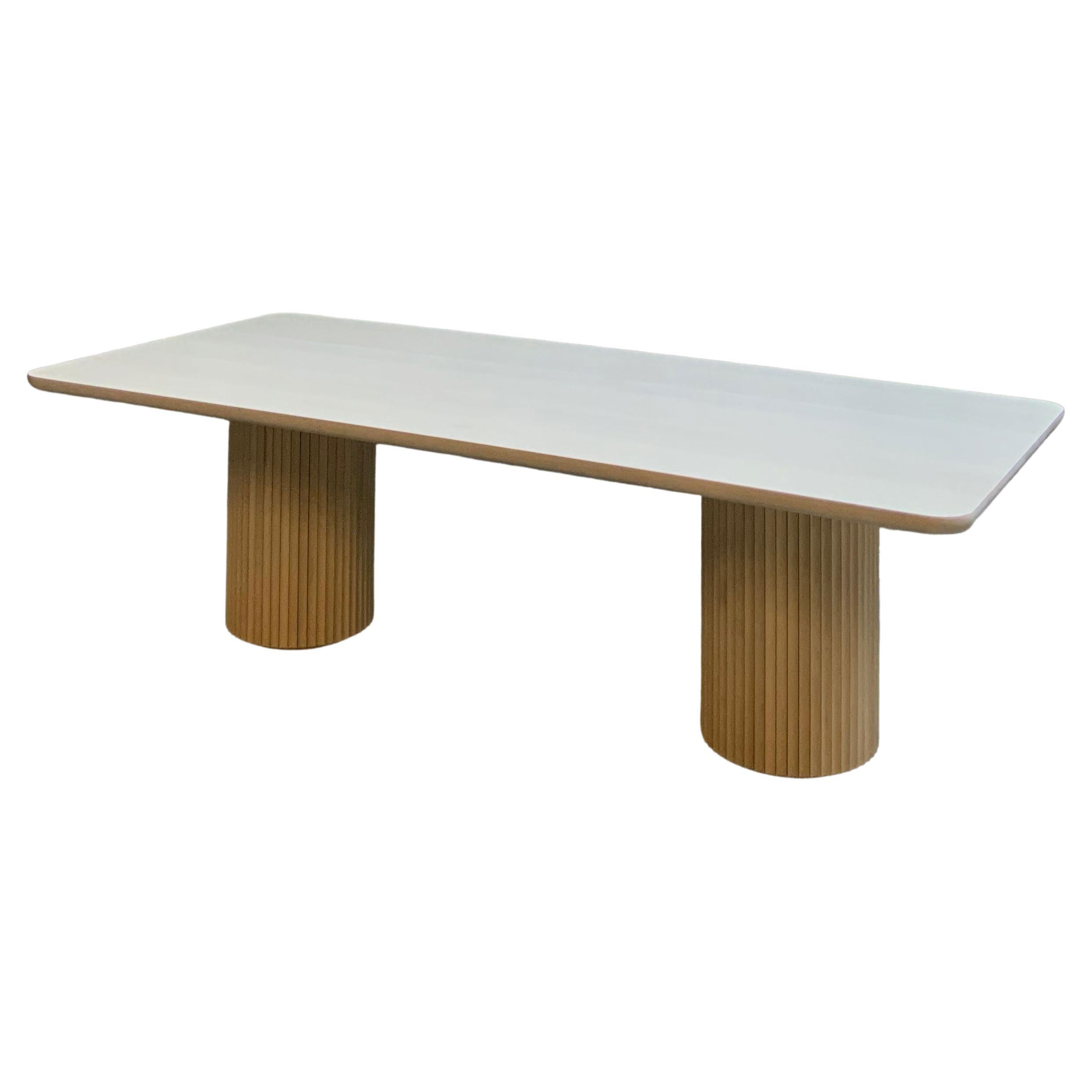 The Pilar Dining Table exudes a sense of subtle elegance and character in the space it inhabits. With a solid wood top and fluted double pedestal base, the table is plenty sturdy without looking heavy. The table seats eight and has enough extra room