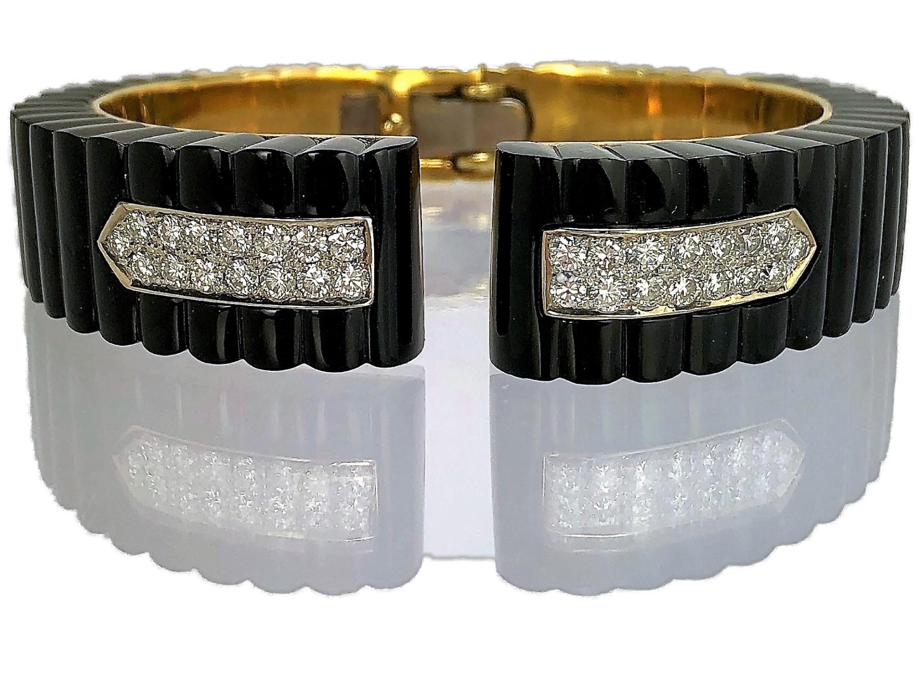 Fashioned in 18k yellow gold, this ultra chic split front cuff sports two fluted
onyx sections in the front, set with 30 diamonds weighing an approximate
total of 2.15CT of overall G Color and VS1 Clarity.  The back panel is gold
and continues the