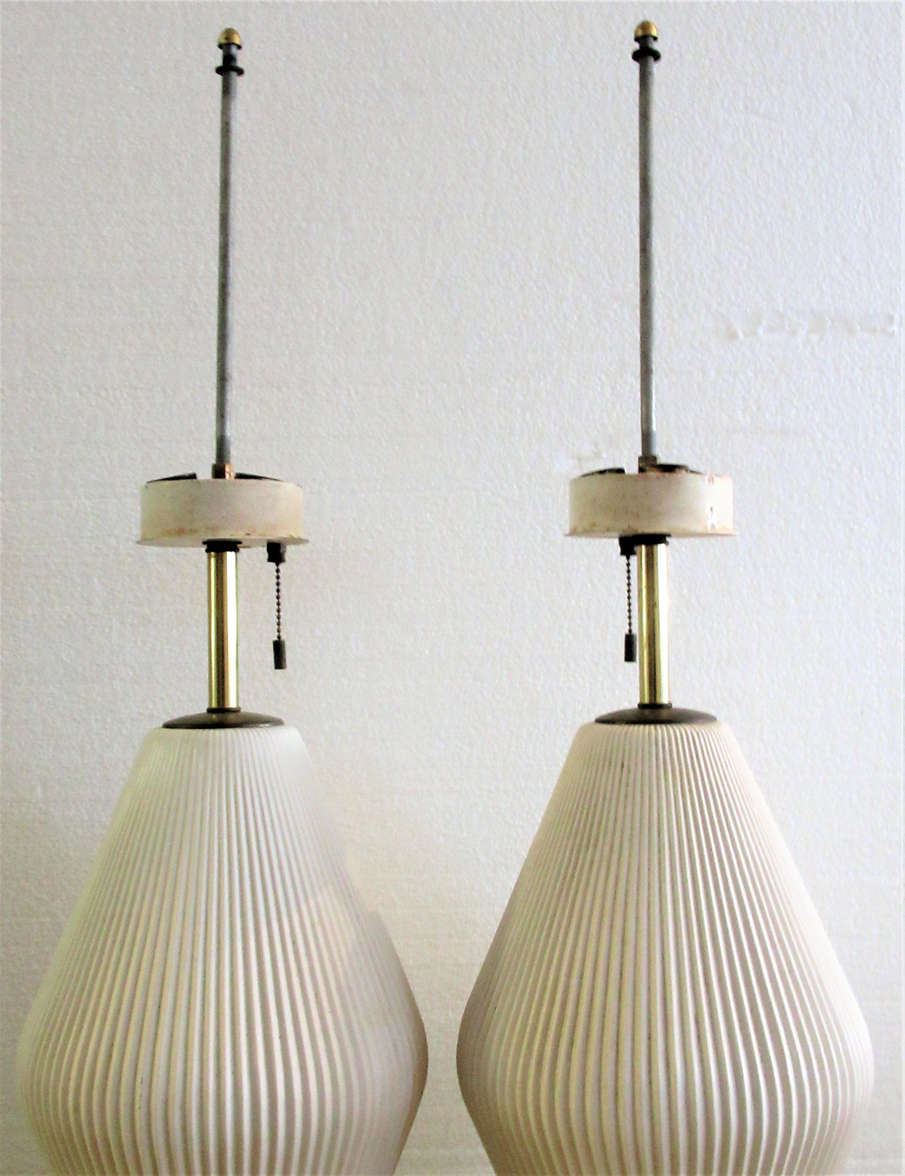 A great looking pair of fluted white porcelain and brass table lamps by Gerald Thurston for Lightolier in good all original condition, circa 1950s. Look at pictures and read condition report.