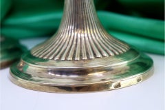 Fluted silver candlesticks with reliefs and beaded circular bases
