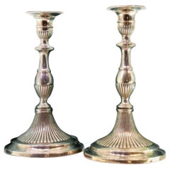 Fluted silver candlesticks with reliefs and beaded circular bases