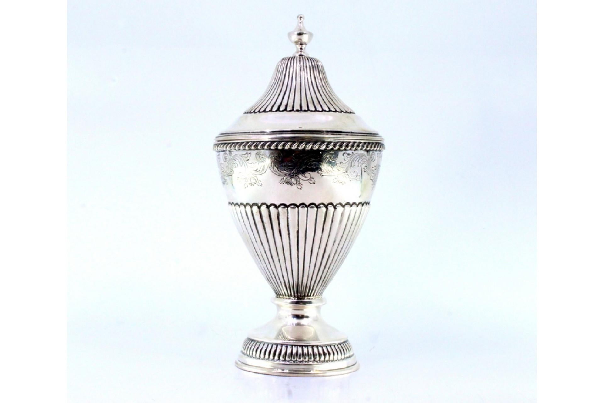 Descrizione: Vaso scanalato in argento con motivi vegetali incisi e un pomello sul coperchio rimovibile. Metallo: Argento. Origine: Portoghese. Marchio: Eagle Head. Peso: 454,55 grammi. Dimensioni: 11 cm x 22,5 cm. Contenuto: 833/1000. Marchio di