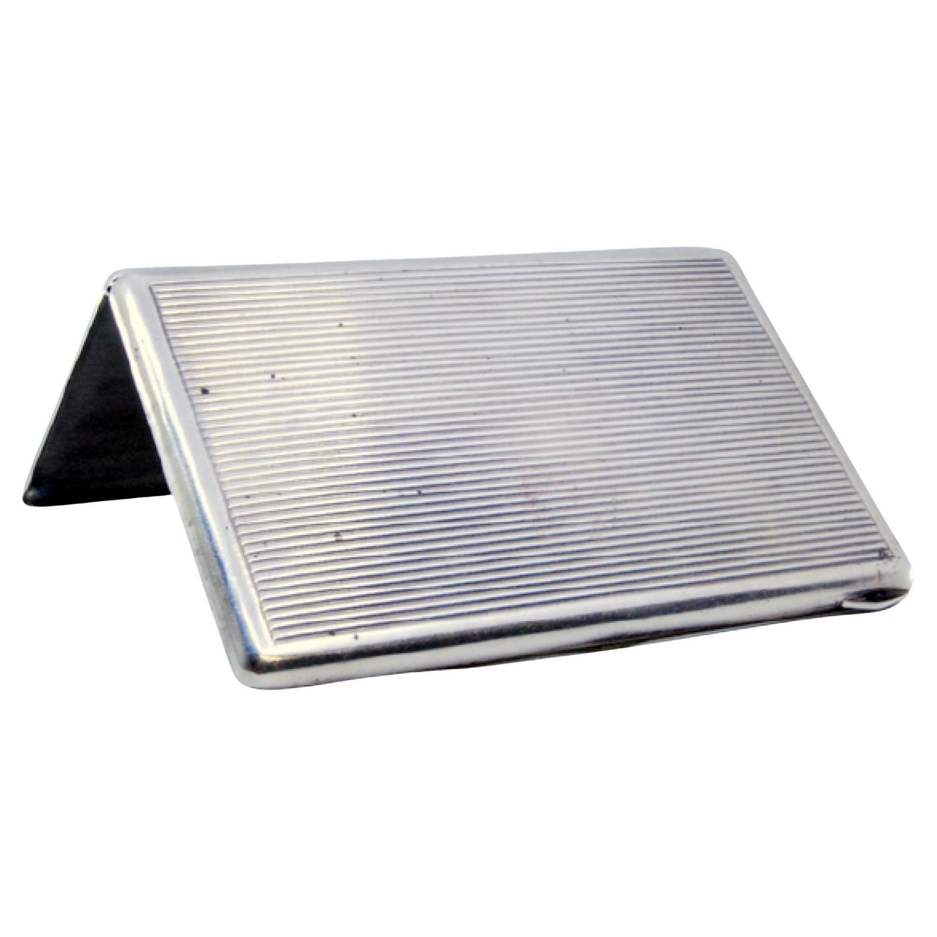 Description: Fluted silver card case with smooth border on the edge and tilting hinge. Metal: Silver. Origin: French. Brand: Cisne. Weight: 76.65 grams. Dimensions: 8.8x5.8cm. Content: 950/1000. Assay Mark: Yes, used for unknown manufacturers.