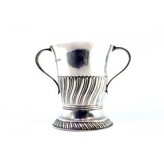 Fluted silver cup on a circular base with friezes