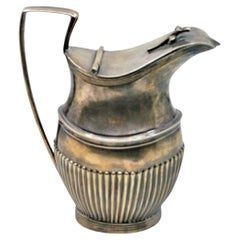 Fluted silver milk jug with rim friezes and knobbed lid in D. Maria style