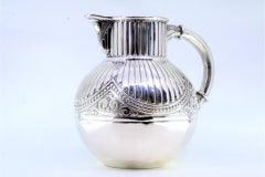 Fluted silver wine jug with a bulging shape and relief with pearly friezes