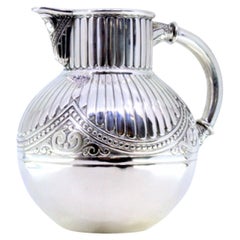 Fluted silver wine jug with a bulging shape and relief with pearly friezes