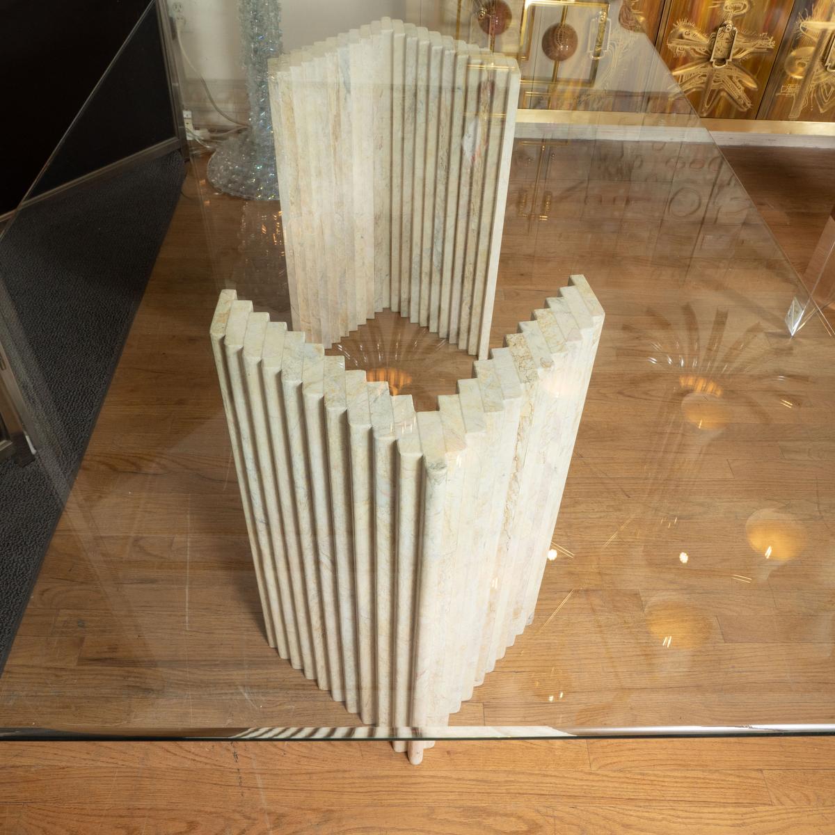 Table de salle à manger en travertin cannelé avec plateau rectangulaire en verre.