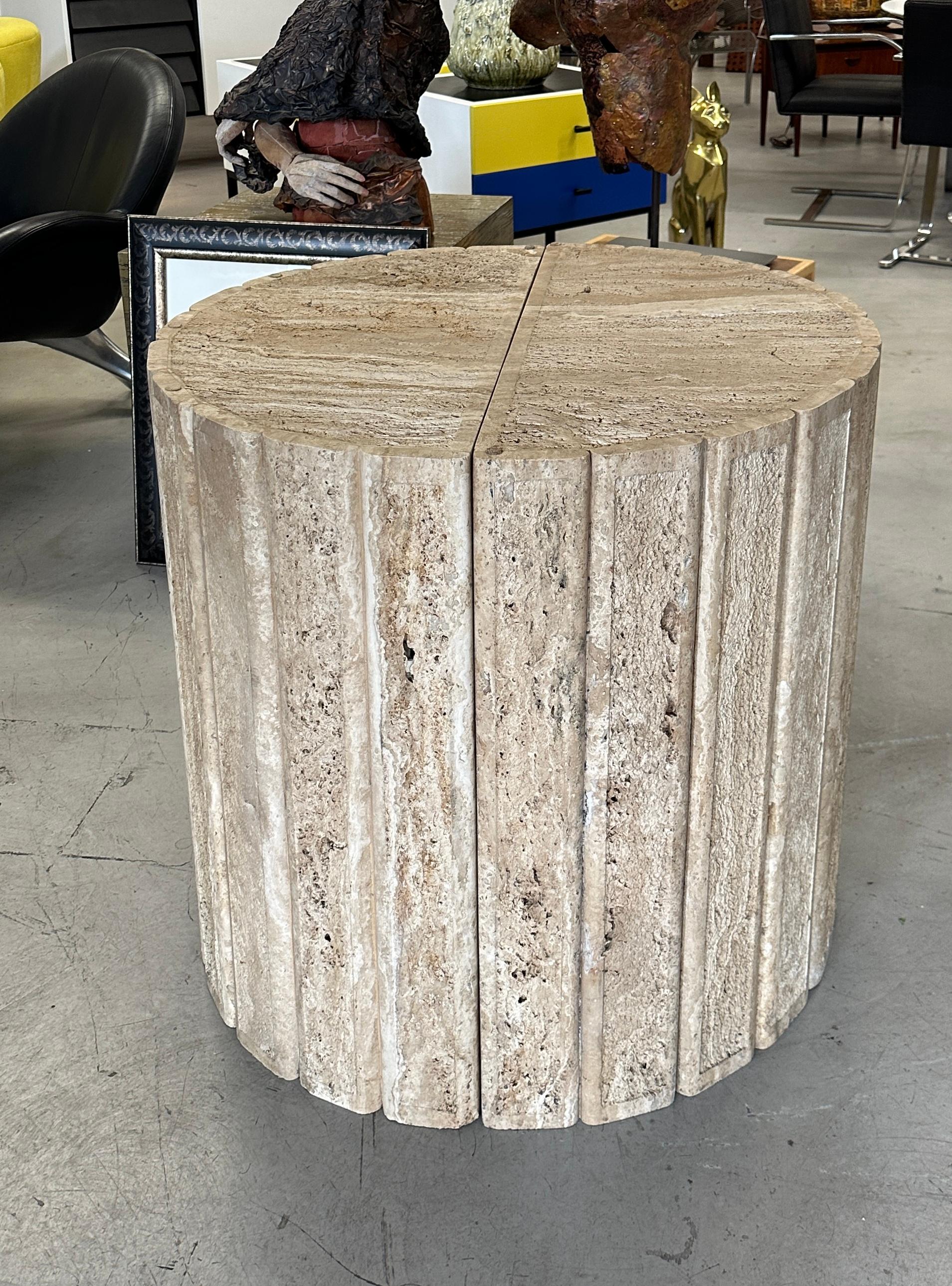 A wonderful pair of fluted travertine tables or table bases in a semi circular shape. We currently have them set as side tables. They are pictured next to a B & B Italia Charles sofa in our gallery for scale. We have used them in the past as table