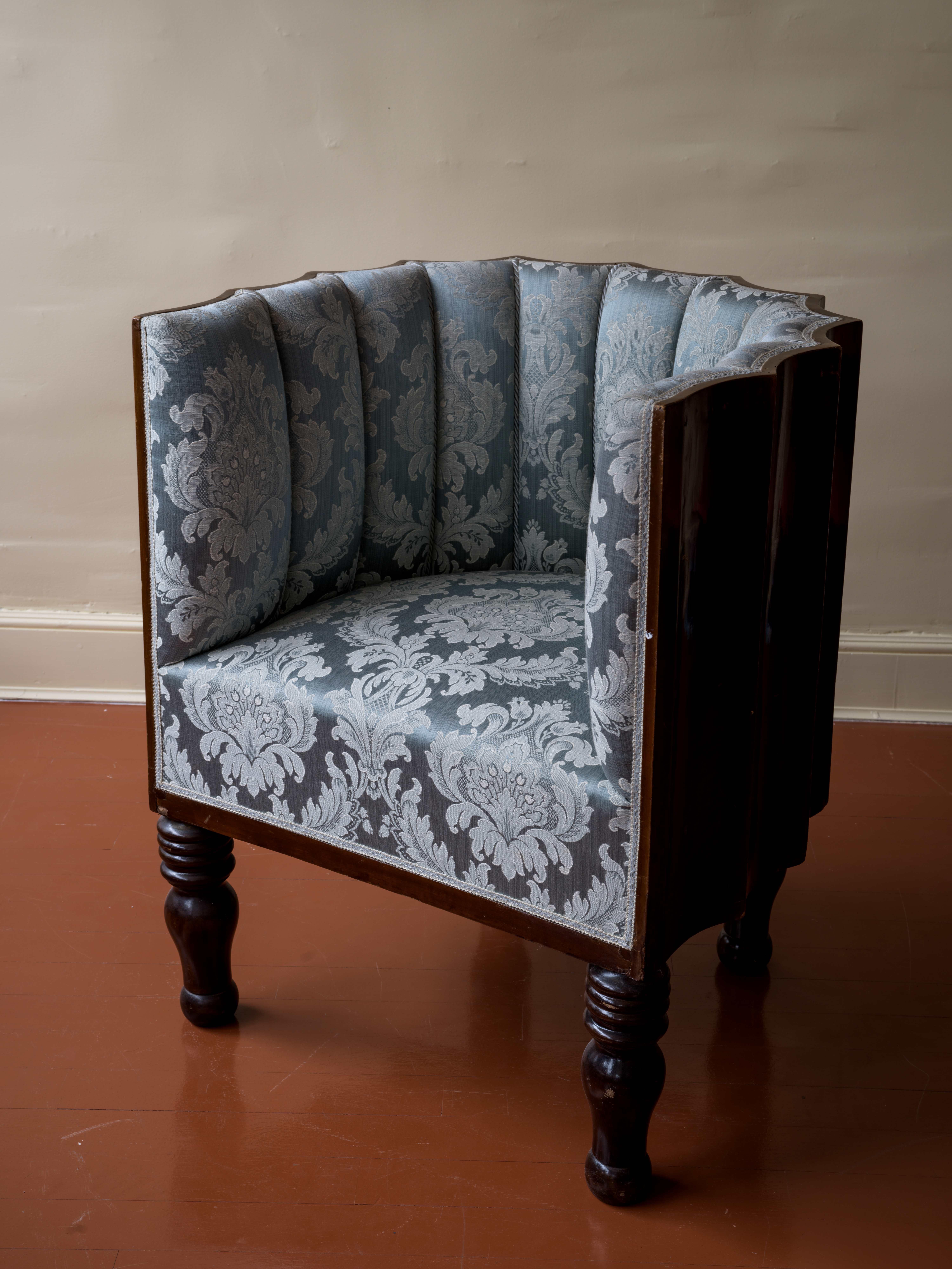 Cette chaise baignoire vintage des années 1940 magnifiquement conservée présente un dossier cannelé en placage d'acajou et de robustes pieds tournés en bois massif. Revêtu d'un luxueux damas de soie et orné d'une dentelle complexe, il respire
