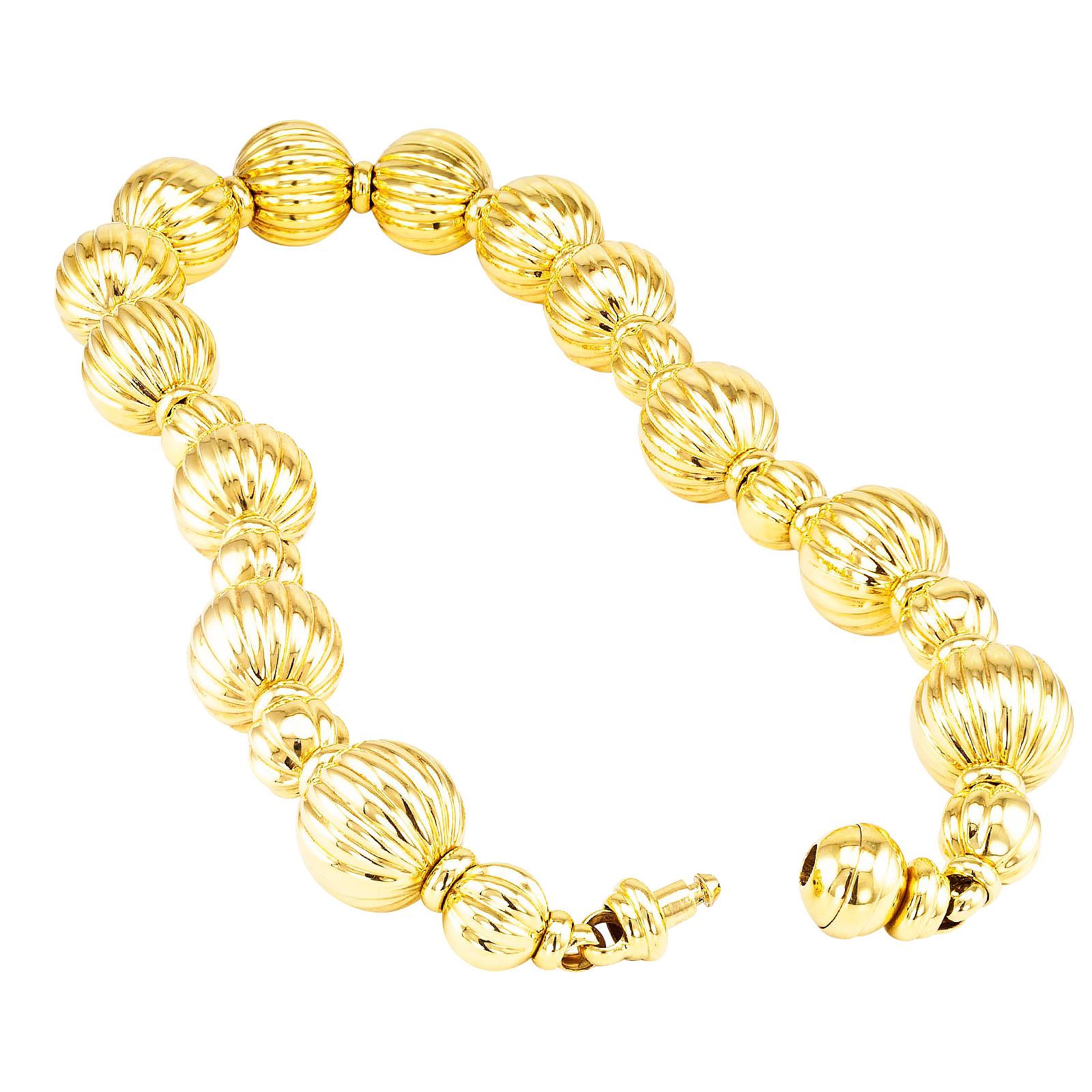 Wide Fluted yellow gold bead necklace circa 1990.

DETAILS:
METAL: 18-karat yellow gold

MEASUREMENTS: larger bead diameter approximately 7/8” or 22.5 mm (2.3 cm),             19.5” (49.5 cm) long overall.

WEIGHT:  137.1 grams

CONDITION: high