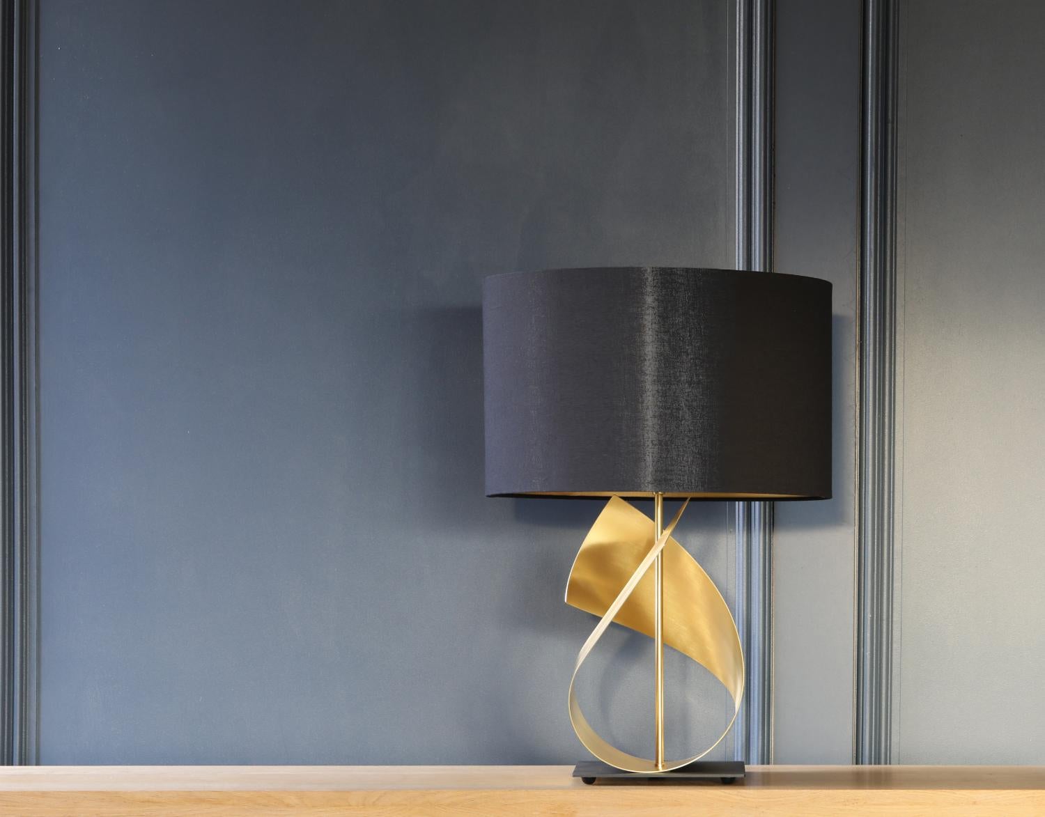 The FLUX is a beautiful, sculptural table lamp, featuring our trade mark sweeping curves in luxurious brushed brass. It is not only a stylish and contemporary light but also a piece of art.

This stunning table lamp makes a statement on its own or