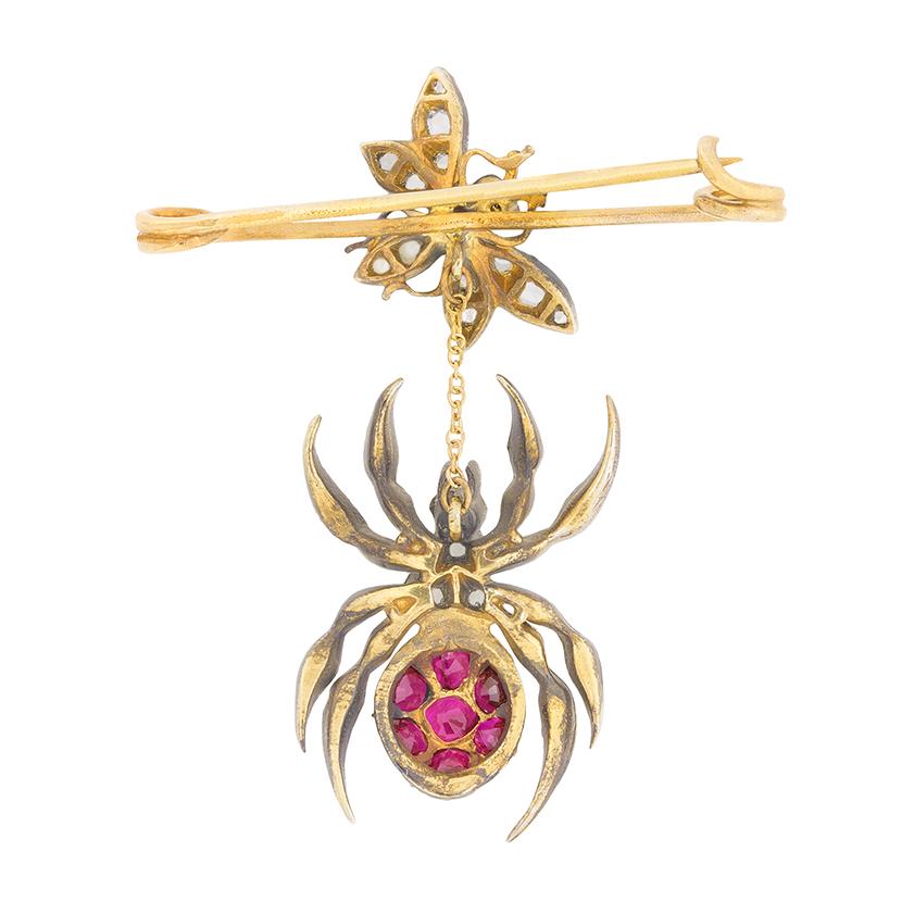 This unique brooch dates back to the 1950s and is a collection of rose cut diamonds, deep red rubies and sparkling blue sapphires. The diamonds total 0.22 carat and are grain set within the body of the hanging spider and fly. The eyes for each