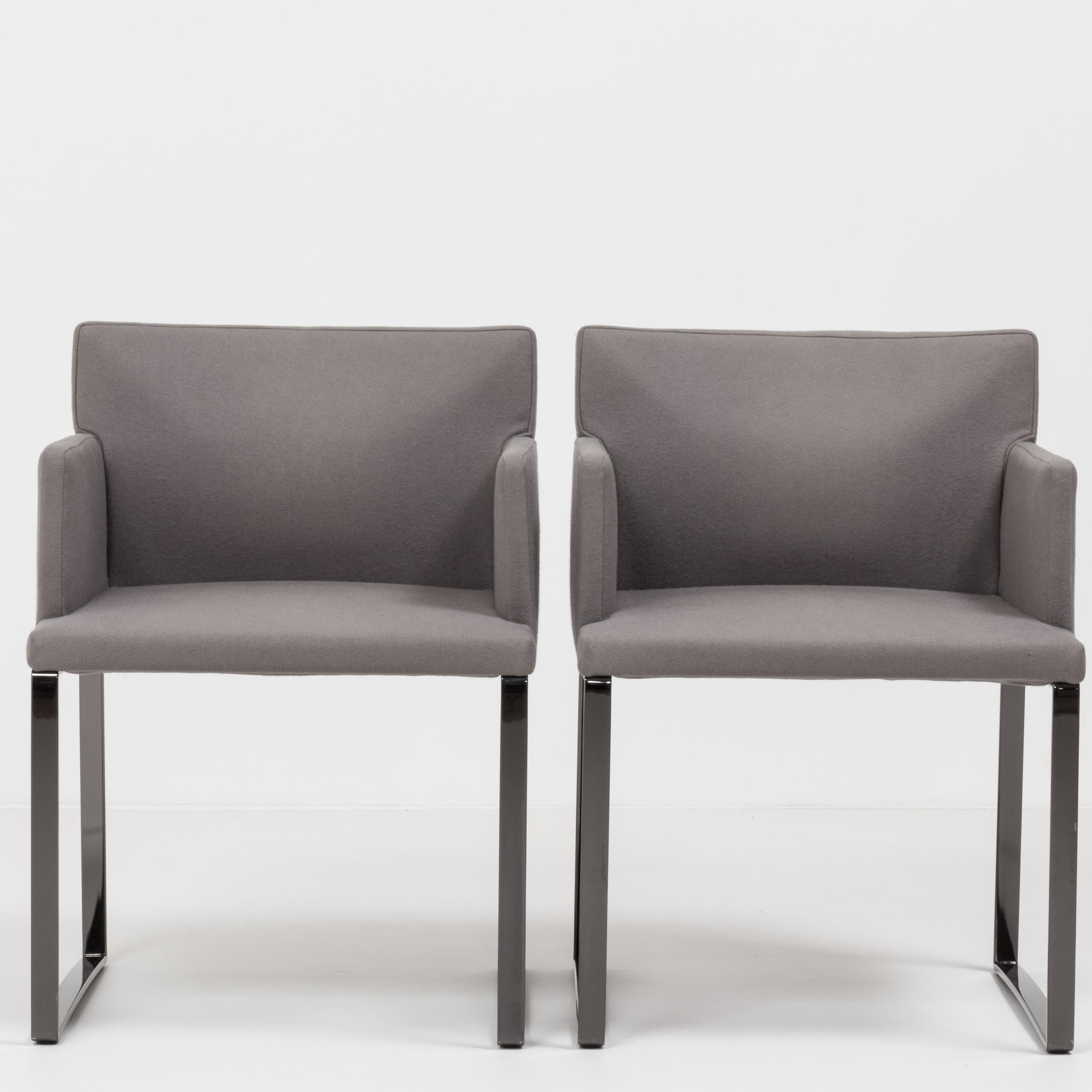 Designed by Rodolfo Dordoni for Minotti, these flat-base Flynt armchairs have a sleek and angular Silhouette.

Featuring square, glossy pewter metal frames, the chairs are upholstered in grey wool fabric with a padded back and seat for ultimate